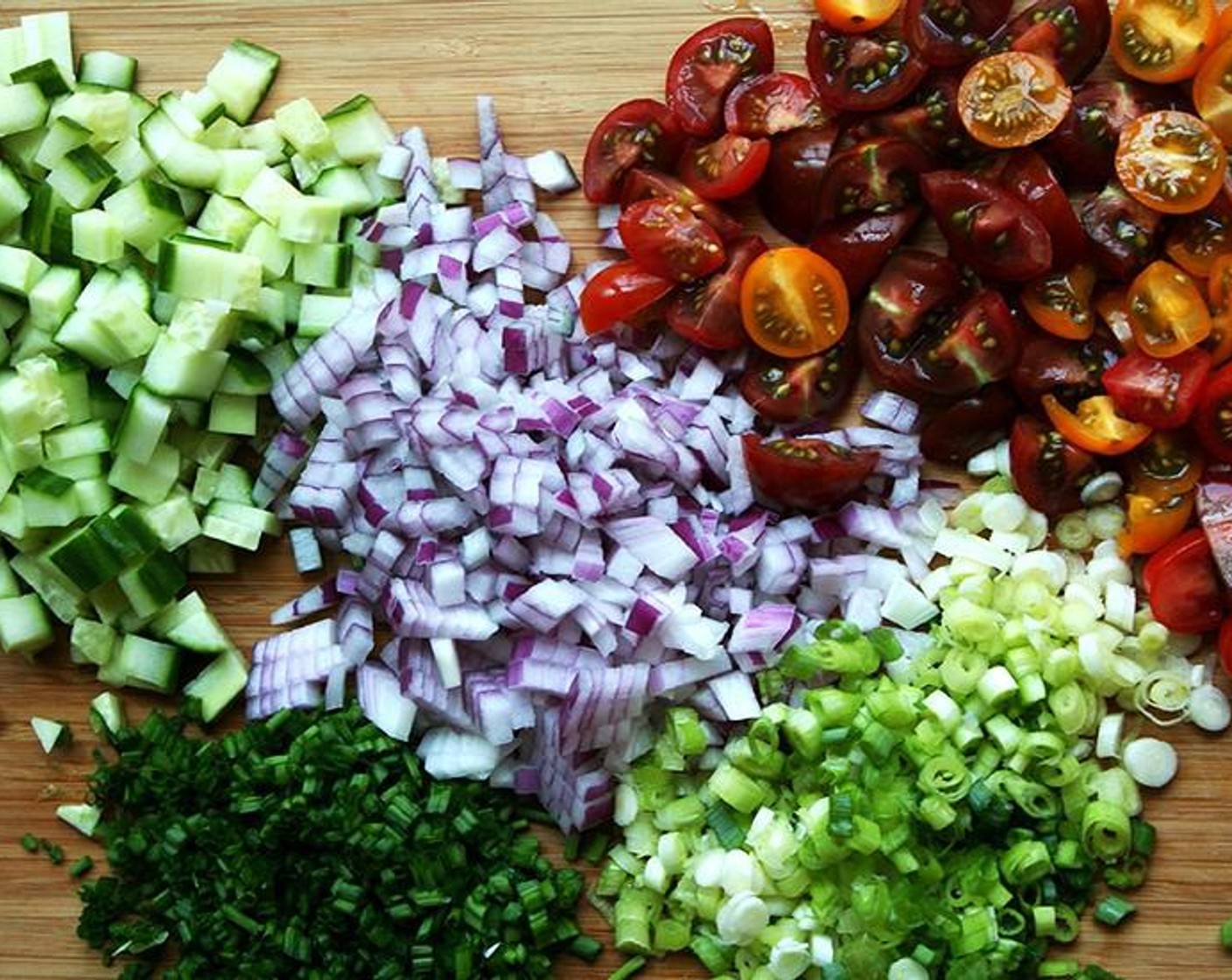 step 2 Meanwhile, finely dice the Red Onion (1). Mince the white and light green portion of the Scallion (1 bunch). Mince the Fresh Chives (1 bunch). Small dice the English Cucumber (1). Halve or quarter the Cherry Tomato (1 cup) depending on their size. Mince the Fresh Parsley (1 bunch). Mince the Fresh Mint (1/4 cup).