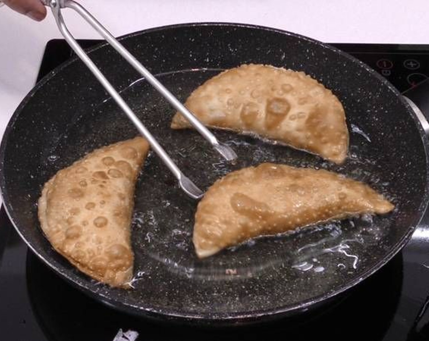 step 5 In a pan add about an inch of Sunflower Oil (as needed) over medium heat. Once it's very hot, fry the empanadas until golden brown and crunchy.
