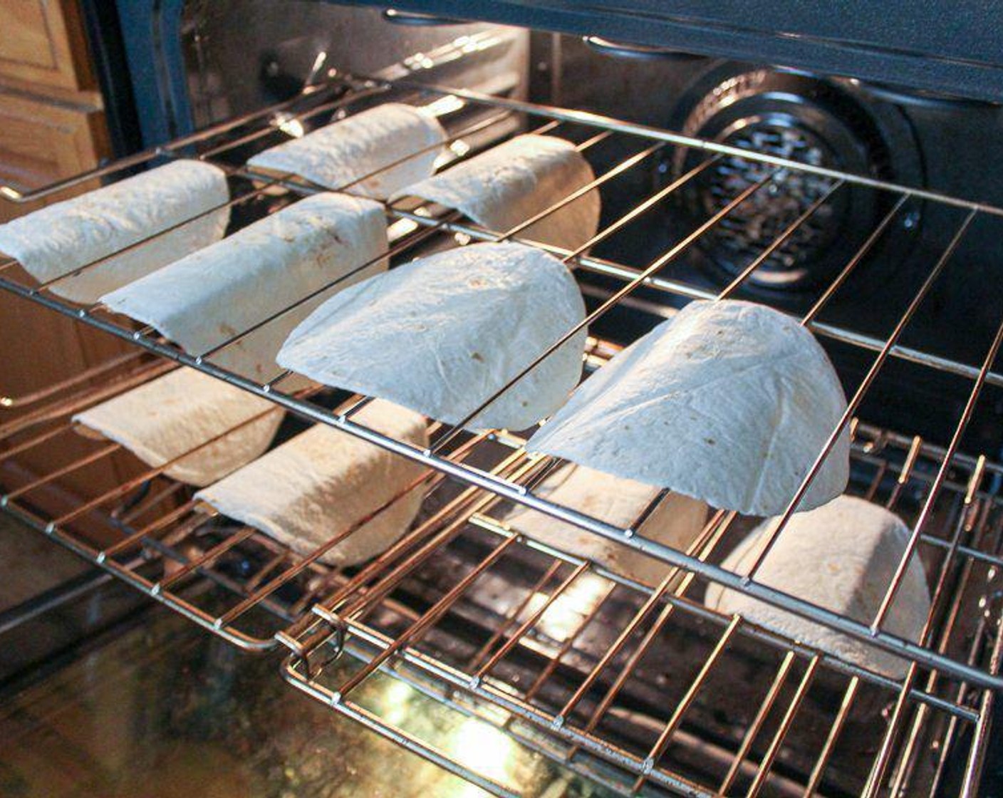 step 2 Once oven is warm, lightly spray one side of each of the 6-Inch Flour Tortillas (10) and drape carefully over the oven rack. Gently press them down into a taco shape. Bake for about 7 minutes, until the shells are golden brown and crispy. Do not over-bake, since they will get more firm as they cool.