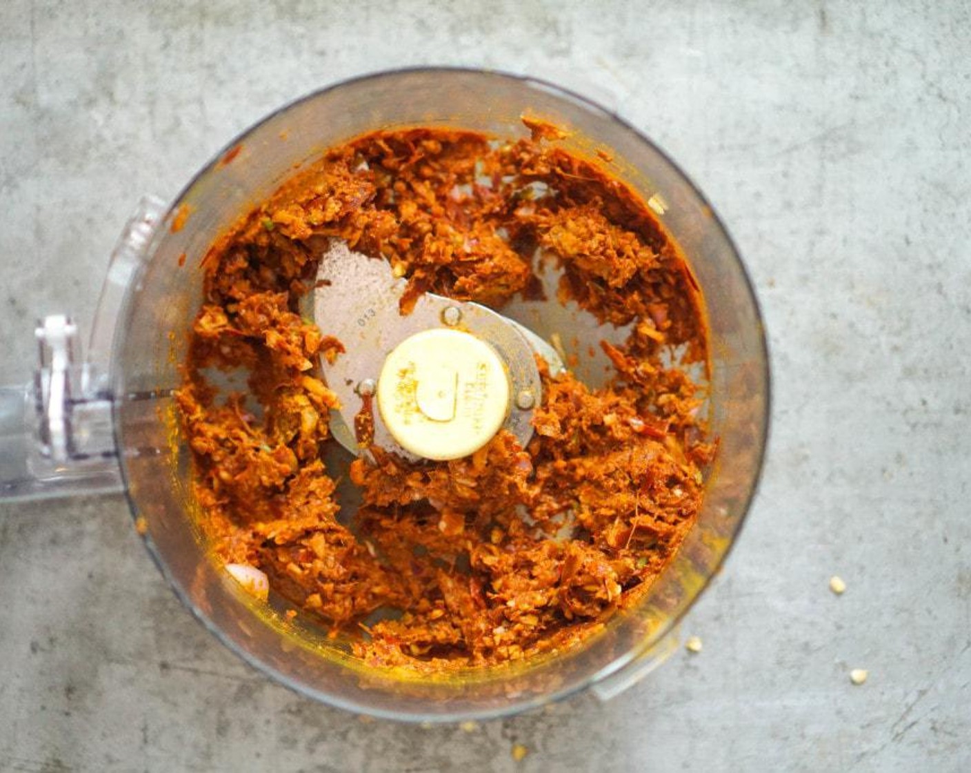 step 2 Add chiles, Shallot (1), Garlic (4 cloves), Fresh Ginger (2 in), Fresh Cilantro (4 Tbsp), Ground Coriander (1 Tbsp), Ground Turmeric (1 Tbsp), Curry Powder (1 tsp), and 3-4 tablespoons soaking liquid in a food processor.