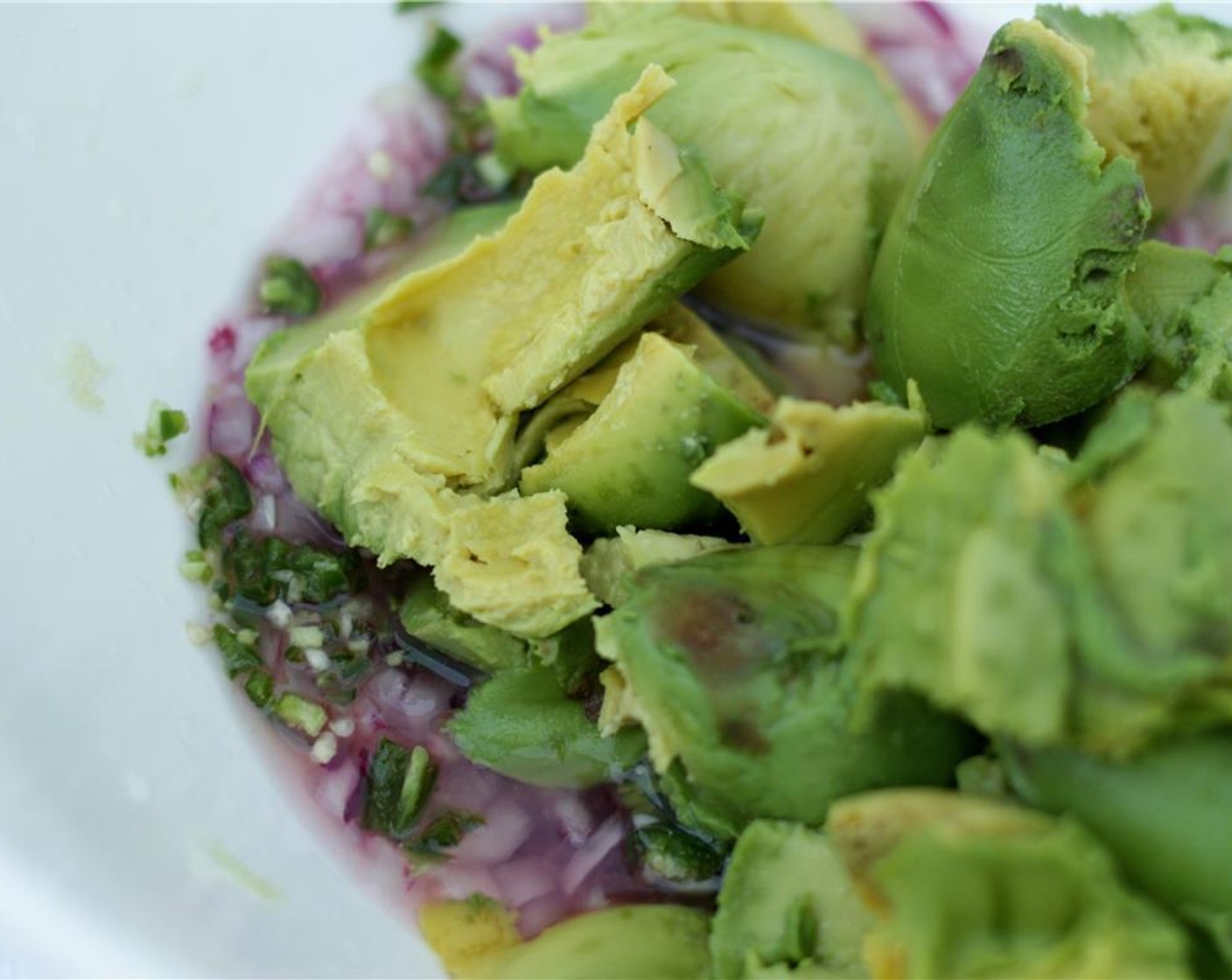 step 7 Scoop the flesh out of the avocados into the bowl. Mash gently with a fork to combine with the onions, peppers, and lime juice.