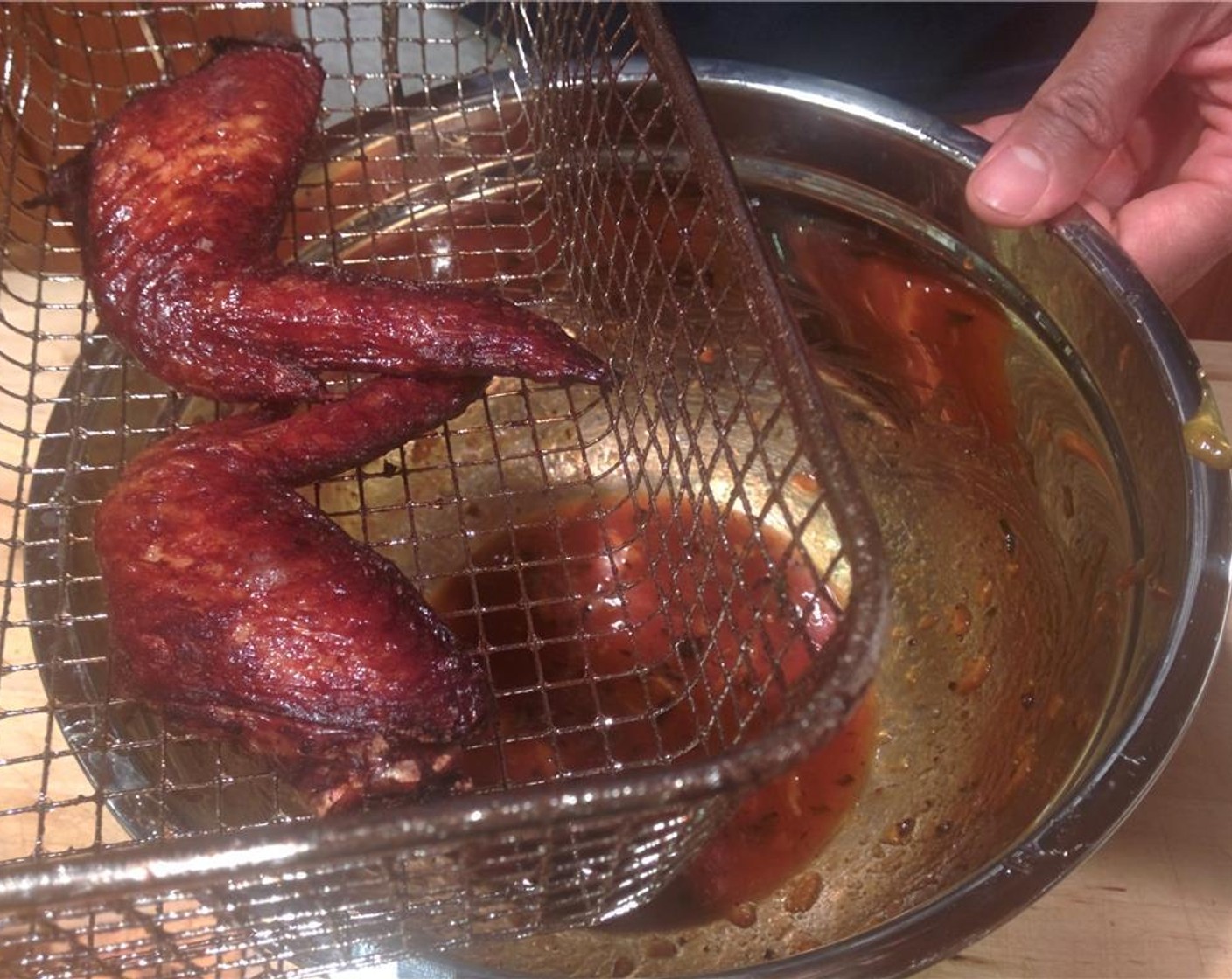 step 10 As the wings finish cooking drain, and then put them in the bowl with the tangerine sriracha mixture.