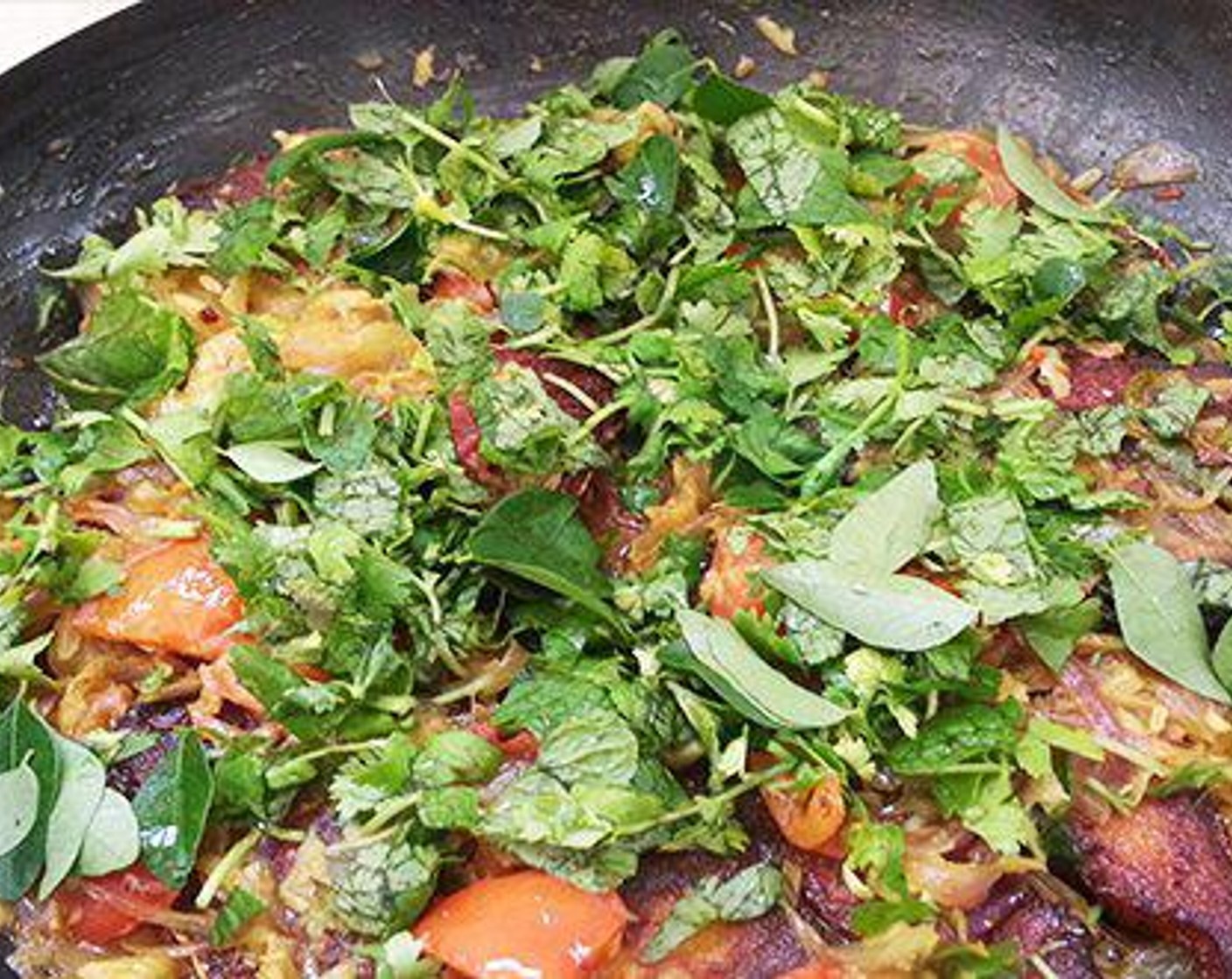 step 5 Add Tomato (1) and Salt (to taste). Cook until the tomato is done. Add fried fish pieces to the masala and cover.