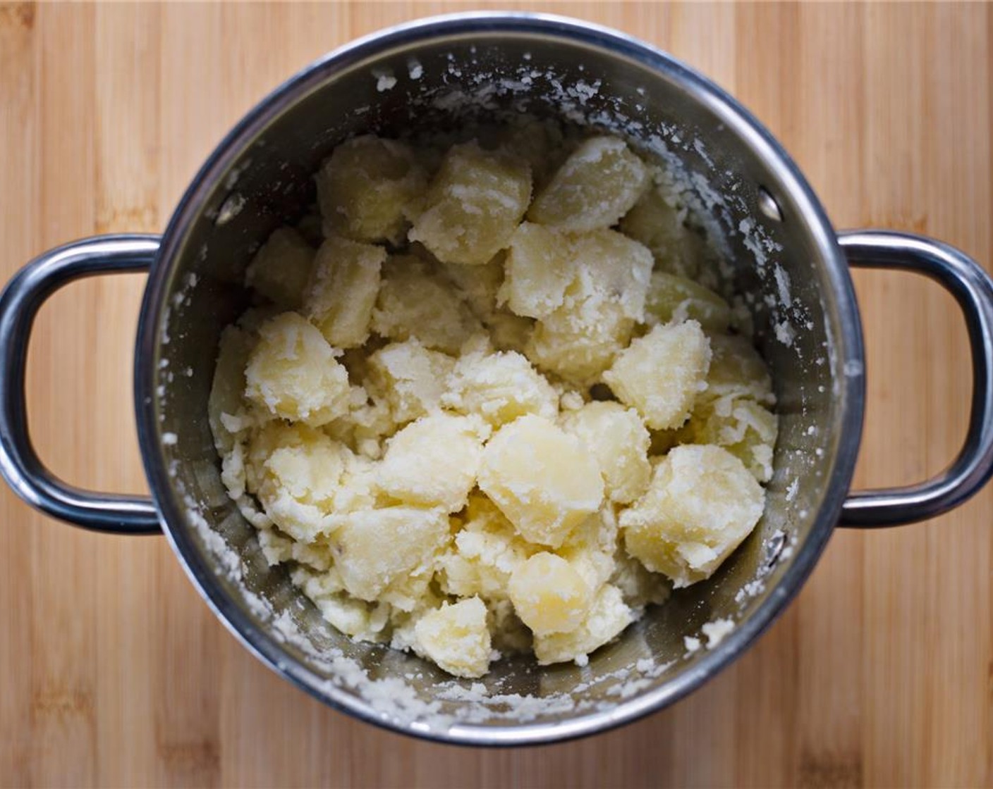 step 8 Vigorously shake the potatoes in the lidded pot to roughen the edges.