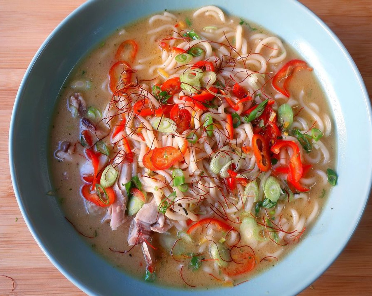 step 5 Add the rest of the shredded chicken to a serving bowl. Top with the noodles from the soup, cover with the rest of the soup and garnish with more Scallions (2 Tbsp), more Chili Peppers (to taste) and Chili Threads (to taste).