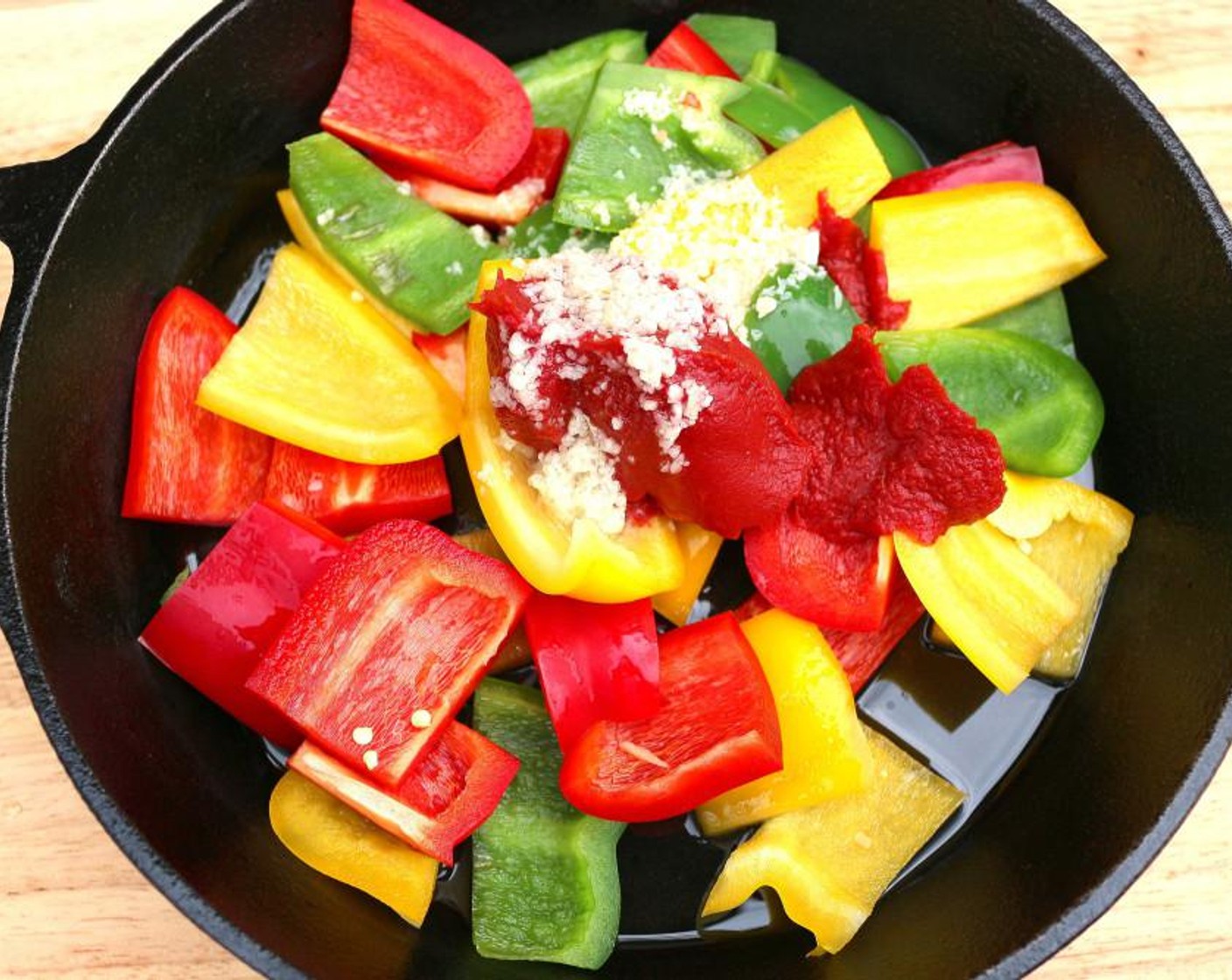 step 2 Cut Yellow Bell Pepper (1), Green Bell Pepper (1) and Red Bell Pepper (1) into 1-inch pieces and add to Olive Oil (1 Tbsp) in a medium hot pan. Add Tomato Paste (1 Tbsp), Garlic Paste (1 tsp), Dried Oregano (1 tsp), Kosher Salt (to taste) and Cayenne Pepper (to taste).