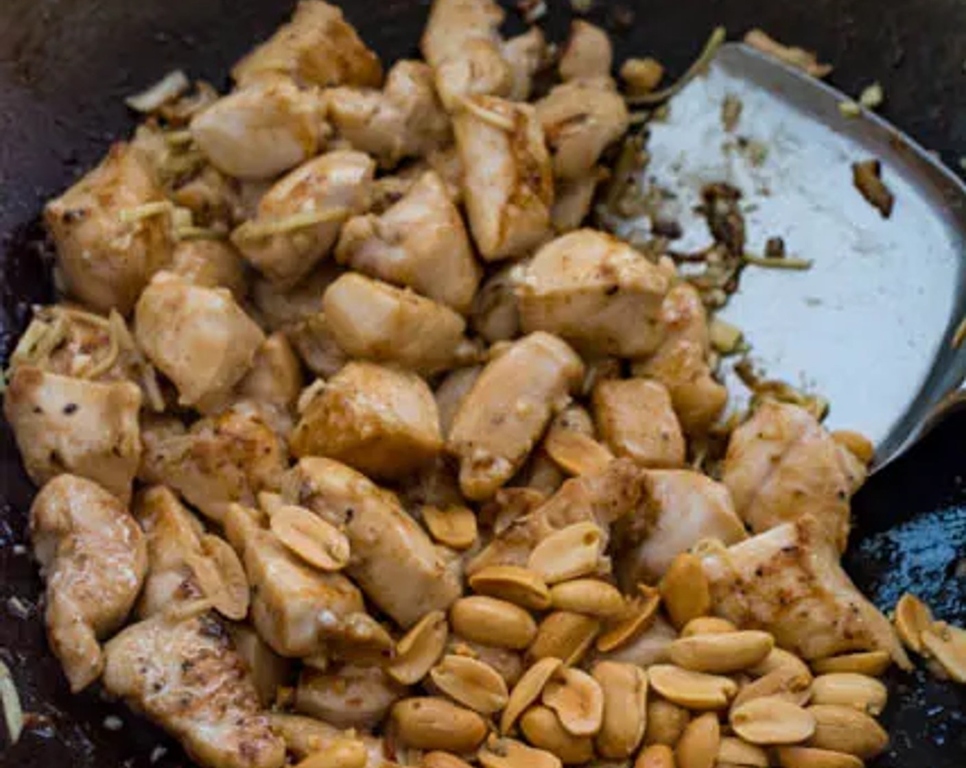 step 6 When the chicken is mostly cooked, add Garlic (2 cloves) and Fresh Ginger (2 Tbsp) to the wok. Stir-fry until the chicken is cooked all the way through, then add Dry Roasted Peanuts (1/4 cup).