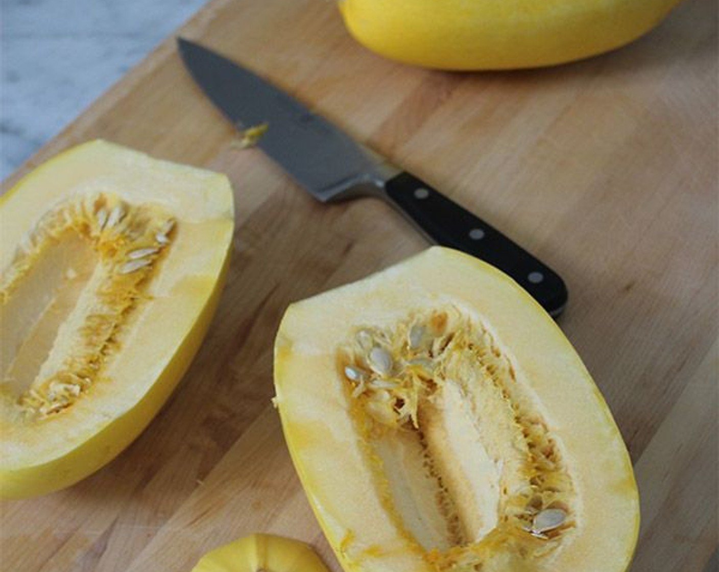 step 2 Trim the stem from each Spaghetti Squash (2), then carefully cut the spaghetti squash in half lengthwise and scoop out the seeds and pulp.