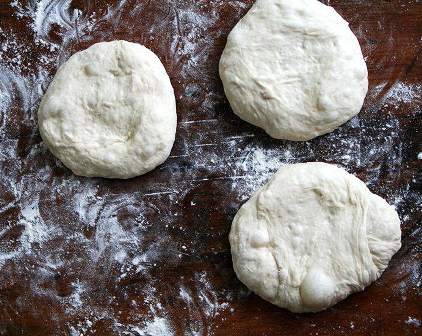 step 4 Transfer the dough to a floured work surface. Gently shape it into a rough ball. Divide into 6 equal portions. Working with 1 portion at a time, quickly shape into a ball. Dust dough with flour then set aside on a work surface or a floured baking sheet. Repeat with remaining portions.