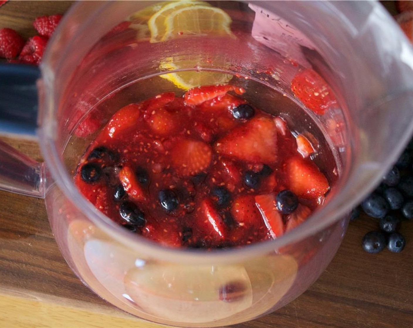step 3 In a large pitcher, add half of the raspberries, blueberries and strawberries, along with the juice and sugar. Muddle until completely broken down.