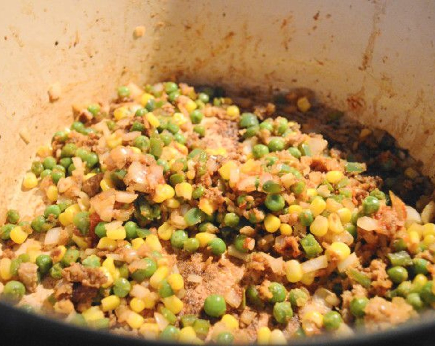 step 4 Add the Onion (1), Jalapeño Peppers (2), Frozen Corn Kernels (1/2 cup), and Frozen Green Peas (1/2 cup) into the pot and let them get soft and fragrant for a minute.