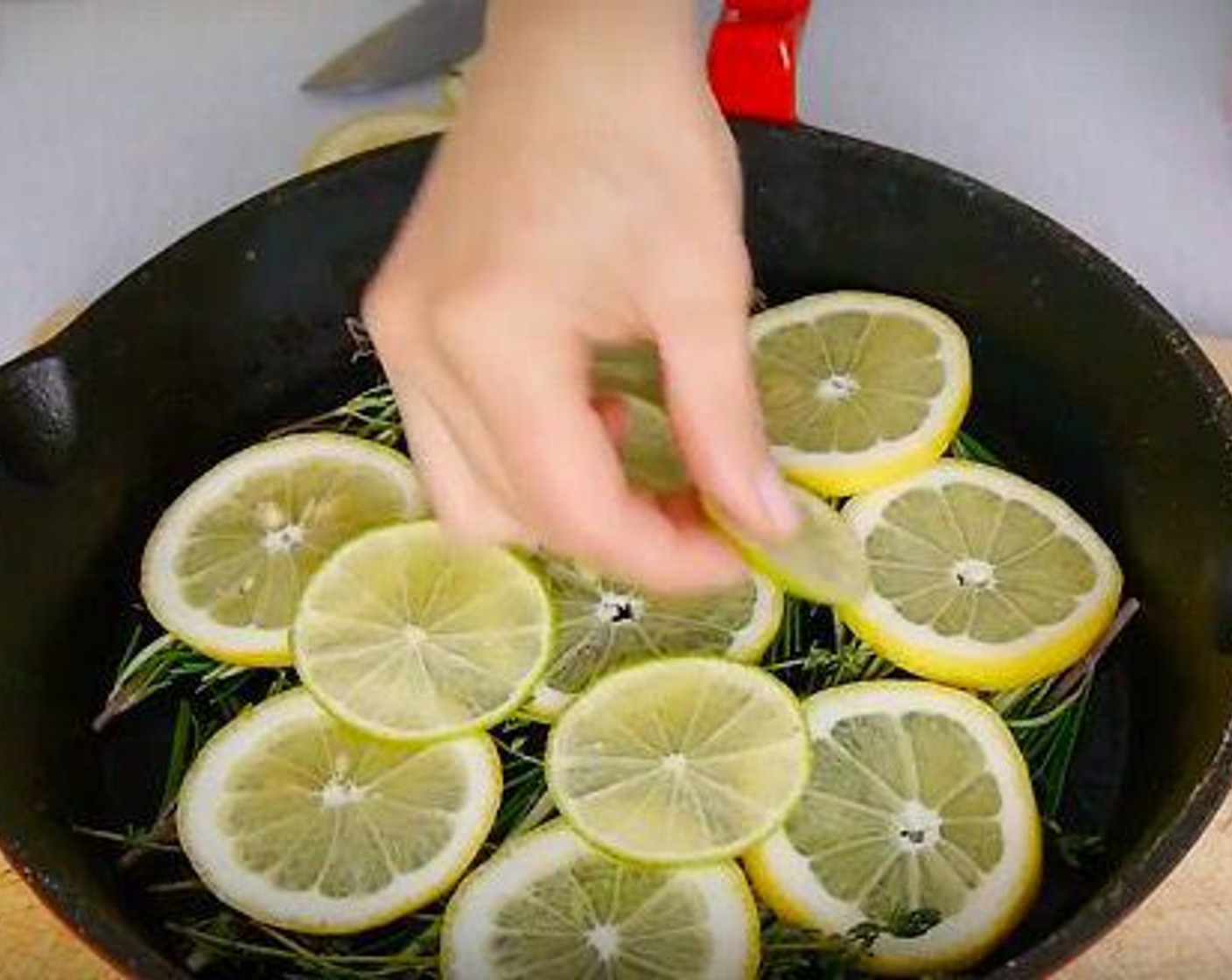 step 5 Add the lemon and lime slices, then arrange the chicken thighs skin side up.