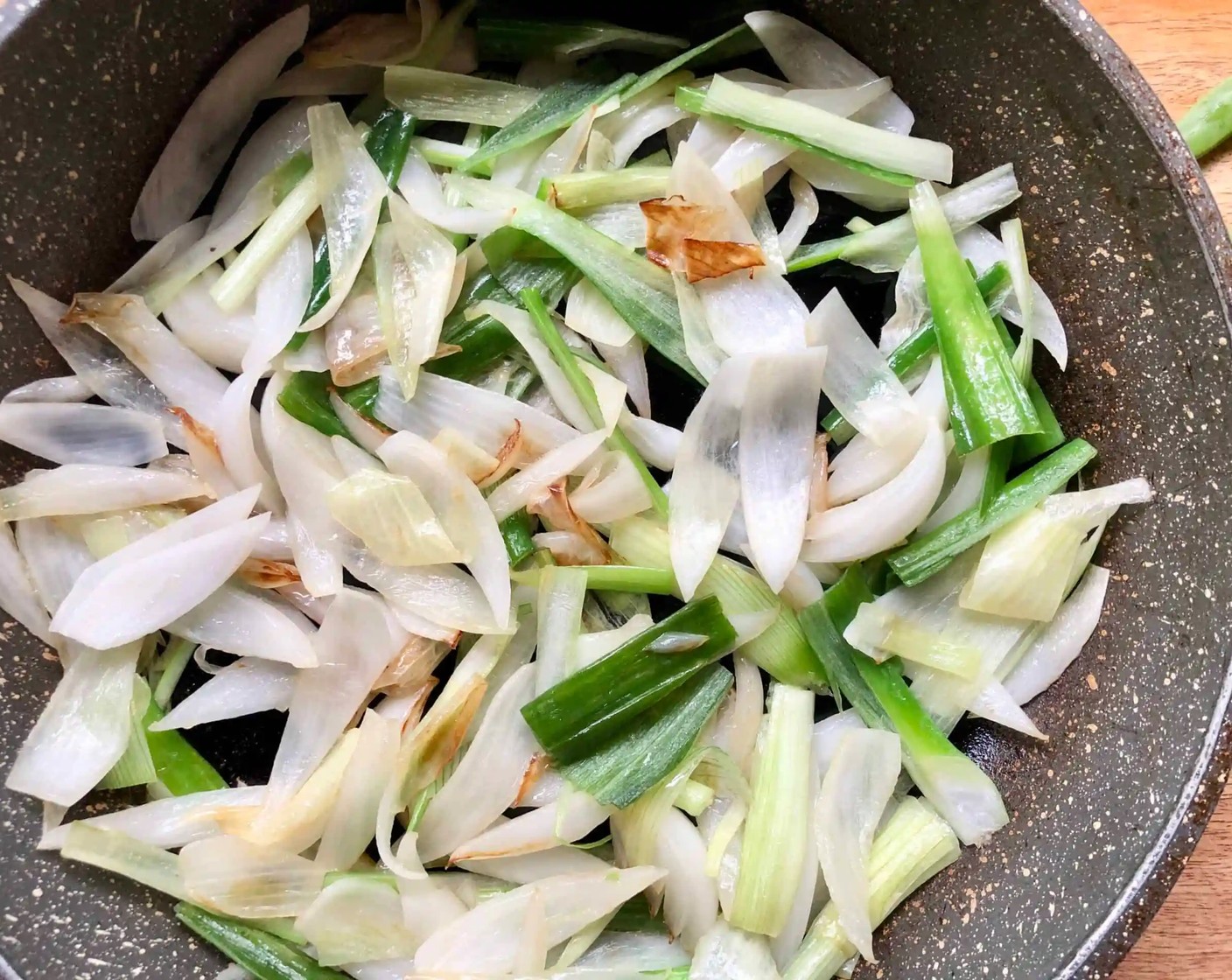 step 9 Heat the remaining Olive Oil (1 Tbsp) in the same skillet. Add the spring onion stems and bulbs, arranging them in a single layer. Cook, tossing once, until charred, for about 4 minutes. Transfer to the bowl with the sugar snap peas; season to taste with Kosher Salt (to taste).