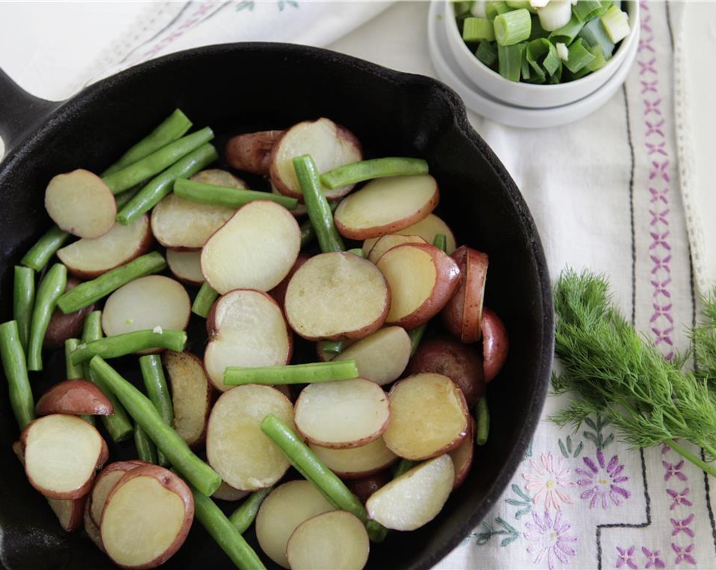 step 7 After 20 minutes, add the French Beans (3/4 cup) to the skillet roast and return to the oven for 5 minutes. Add the Scallion (1 bunch) and Garlic (1 clove) and toss to combine.