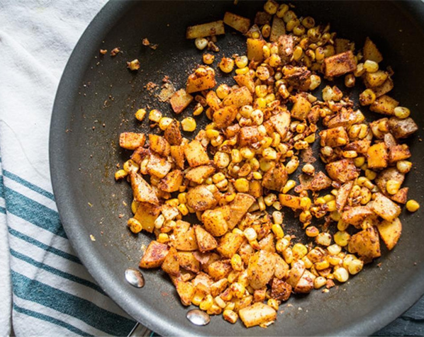 step 2 Add Corn (1 ear) to the pan with potatoes, along with all seasonings; Chili Powder (1 tsp), Ground Cumin (1/2 tsp), Smoked Paprika (1/2 tsp), McCormick® Garlic Powder (1/4 tsp), Ground Turmeric (1/4 tsp), Sea Salt (1 pinch), and Ground Black Pepper (1 pinch).