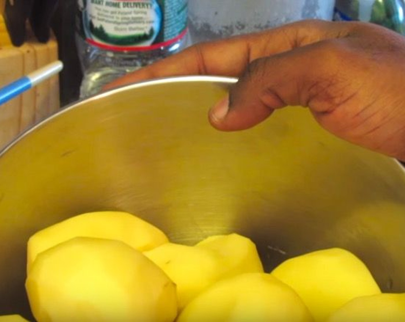 step 1 As you peel the Russet Potatoes (5 lb), place them in a mixture of Water (10 cups) and Orange (1) to keep from browning.