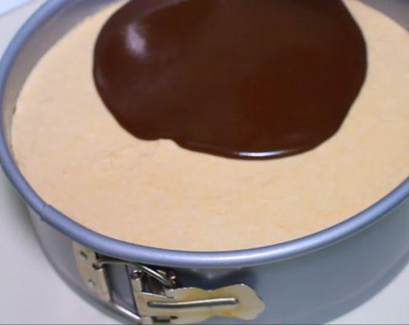 step 5 To make the ganache, heat the Heavy Cream (4 fl oz). Add the Semi-Sweet Chocolate Chips (2/3 cup) to the cream and mix until combined. Pour the ganache over the chilled cheesecake. Use a spatula to spread it evenly. Cool if desired.