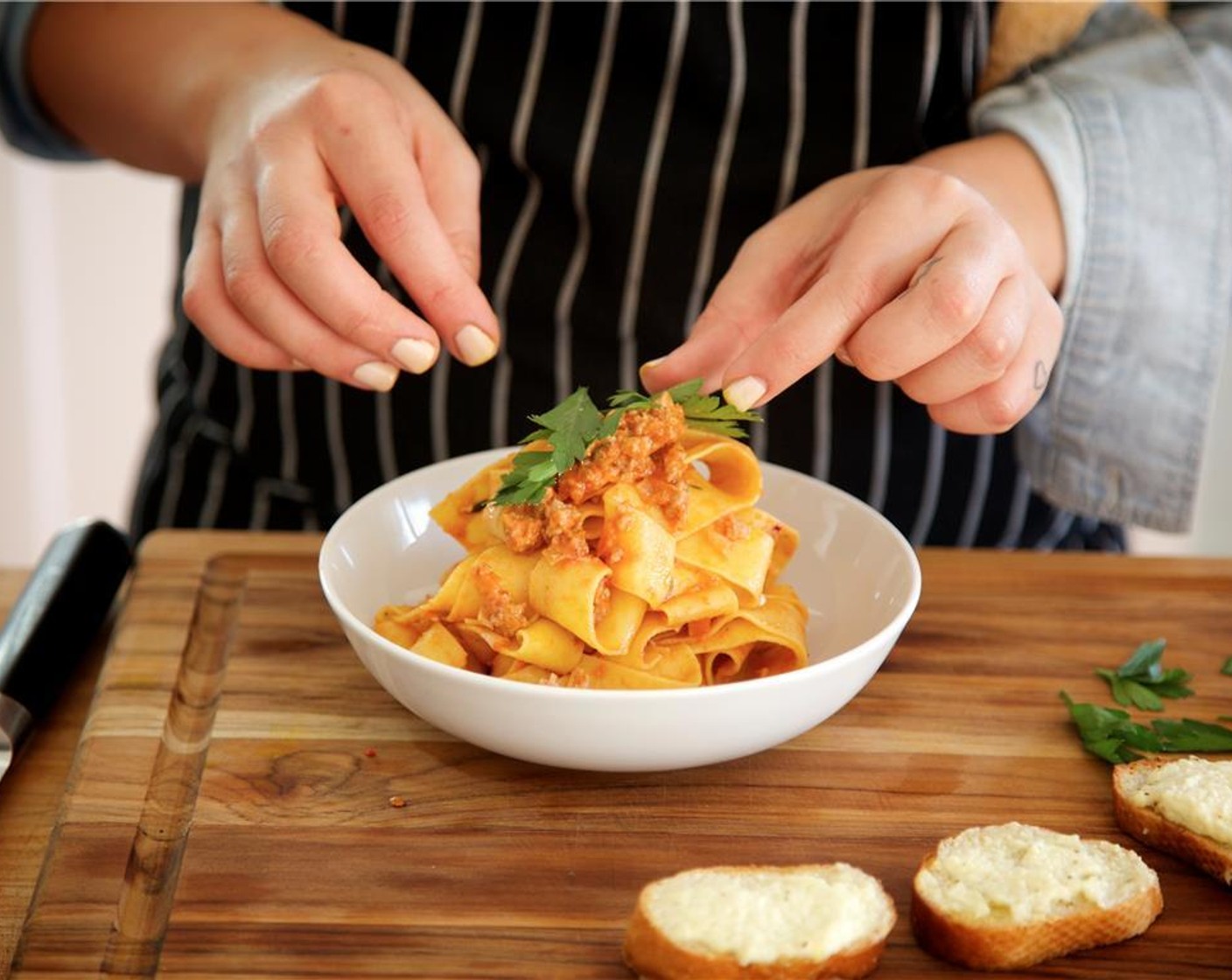 step 16 Distribute the pasta evenly in the center of two bowls. Sprinkle with Parmesan Cheese (1/4 cup) and garnish with the parsley leaves. Place the ricotta toasts around the pasta on the side.