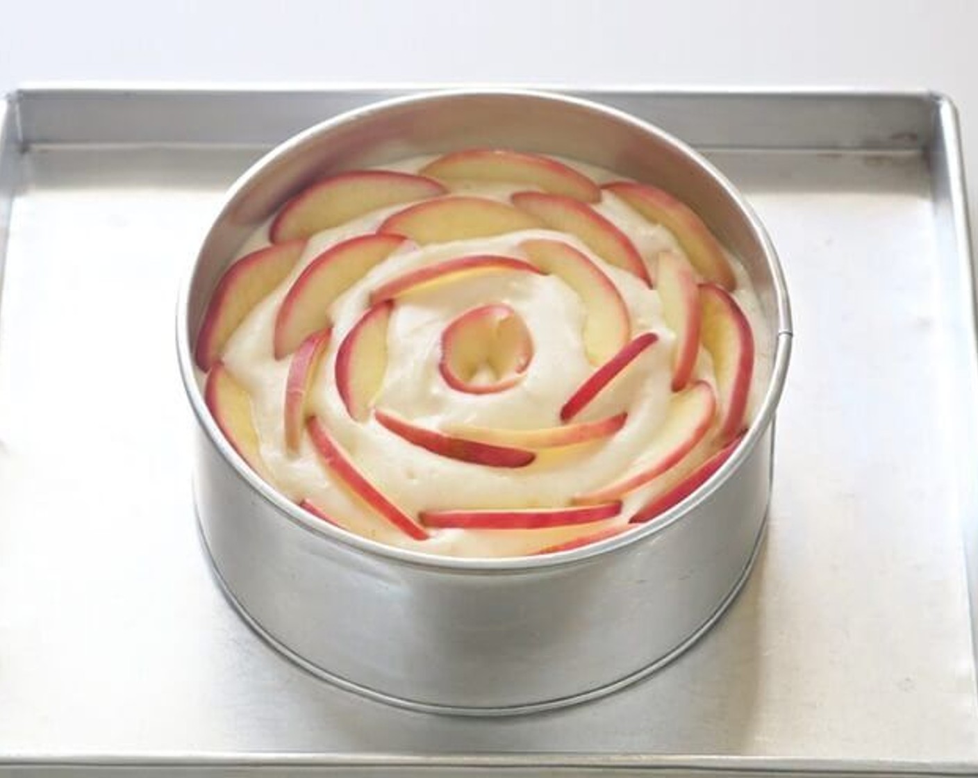step 10 Pour batter into a 7 inch removable cake pan. Gently arrange sliced apples on top of the batter into a rose form.