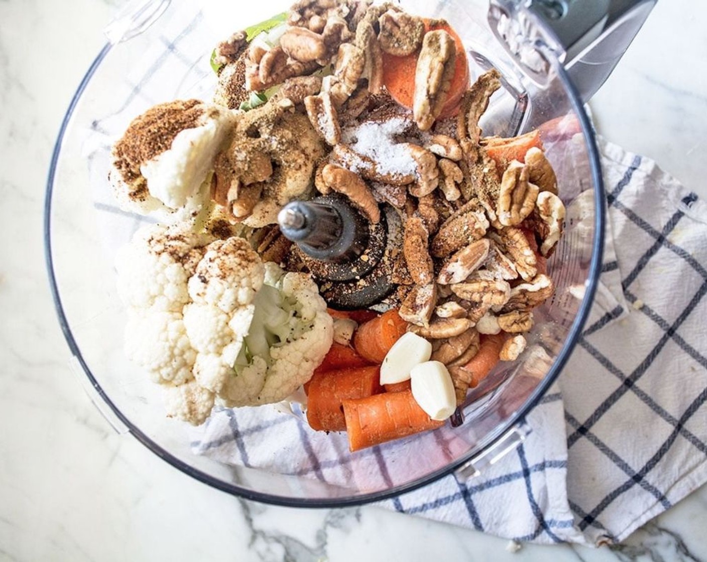 step 2 Add Carrots (3), Cauliflower Florets (1 1/2 cups), Sweet Onion (1/2), Pecan Halves (1 cup), Garlic (2 cloves), Chili Powder (1 tsp), Ground Cumin (1/2 tsp), Chipotle Seasoning (1/4 tsp), and Sea Salt (1/2 tsp) to the bowl of a food processor. Pulse all ingredients until the mixture is evenly ground yet still has some smaller chunks, approximately 10-15 seconds.