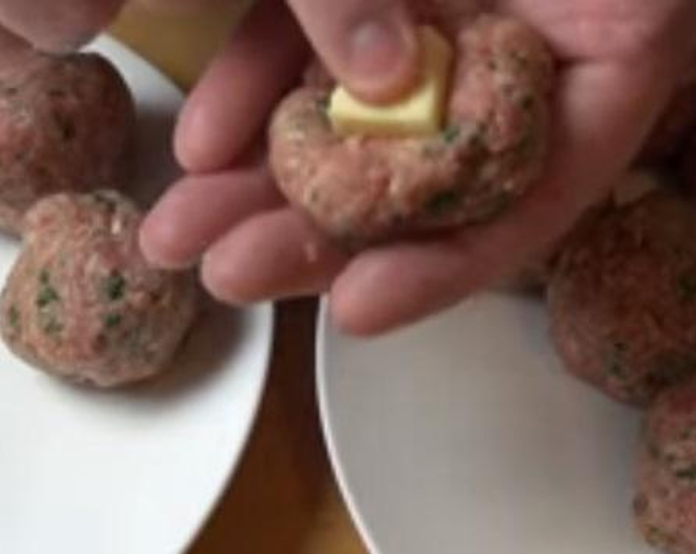 step 3 Take small pieces of the Mozzarella Cheese (to taste), press it into the center of each meatball, and wrap around the meat around the cheese.