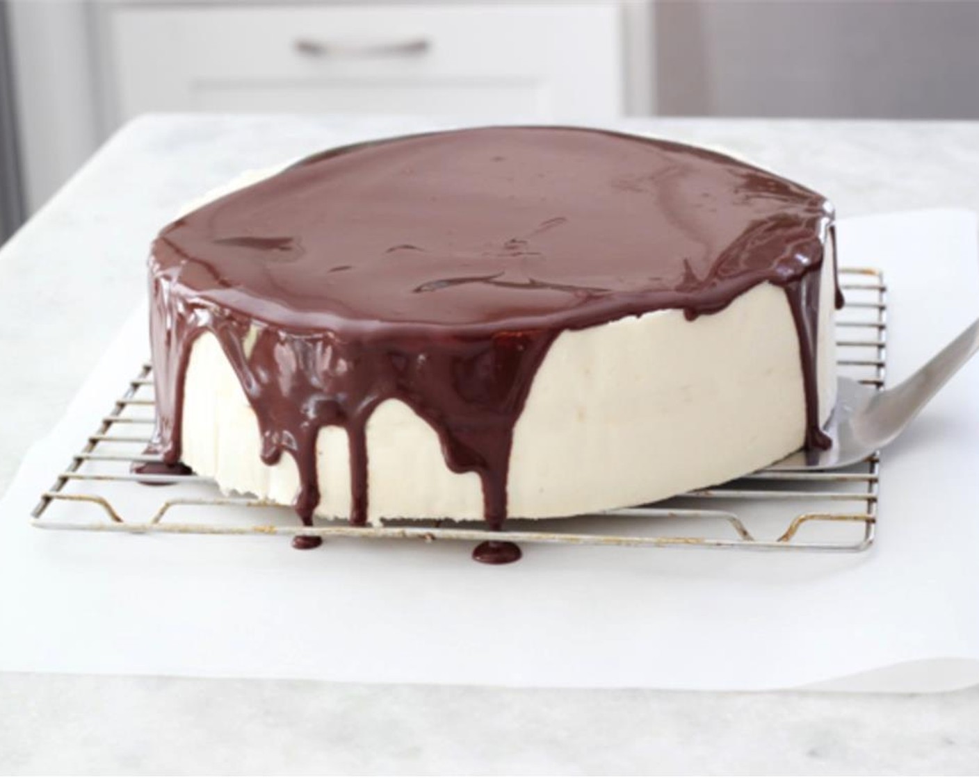 step 31 Pour the chocolate ganache over the top of the cake. I like to pick it up and very carefully swirl the cake so that the excess ganache runs down over the sides of the cake, adding more ganache as necessary, and then let it stand for about 5 minutes, just so that the excess chocolate drips off.