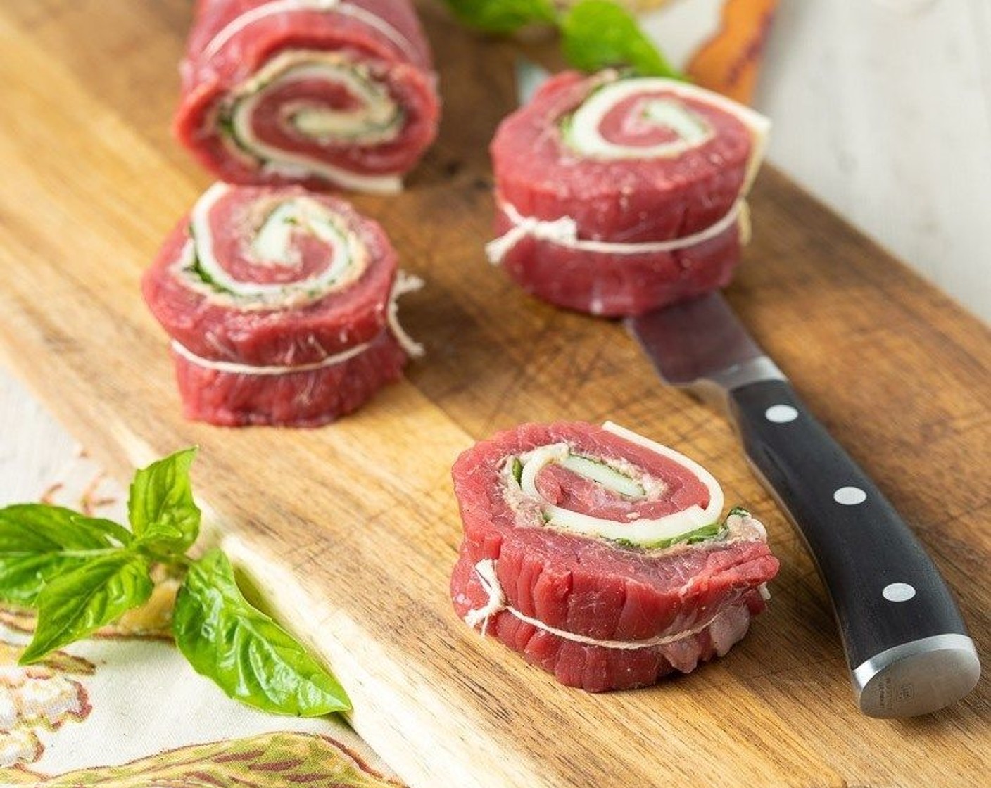 step 6 Using butcher string, snugly tie the rolled steak at 1-inch intervals. Remove toothpicks and cut roll evenly between each piece of string, giving you about 8 one-inch rolls tied in the centre with string.