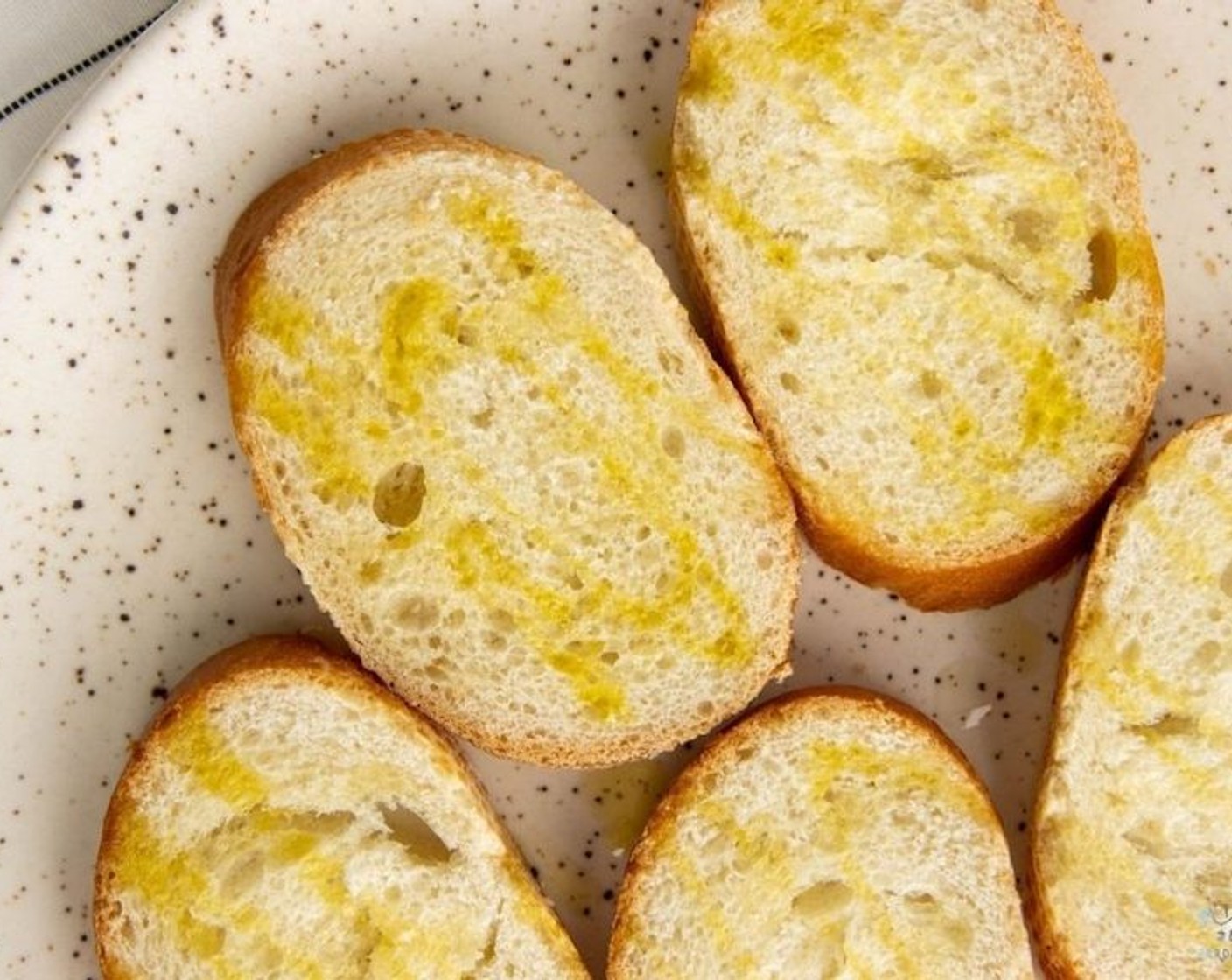 step 2 Brush the Baguette Slices (10 slices) with Olive Oil (1 Tbsp) and toast in the oven for 10 minutes or until lightly golden.