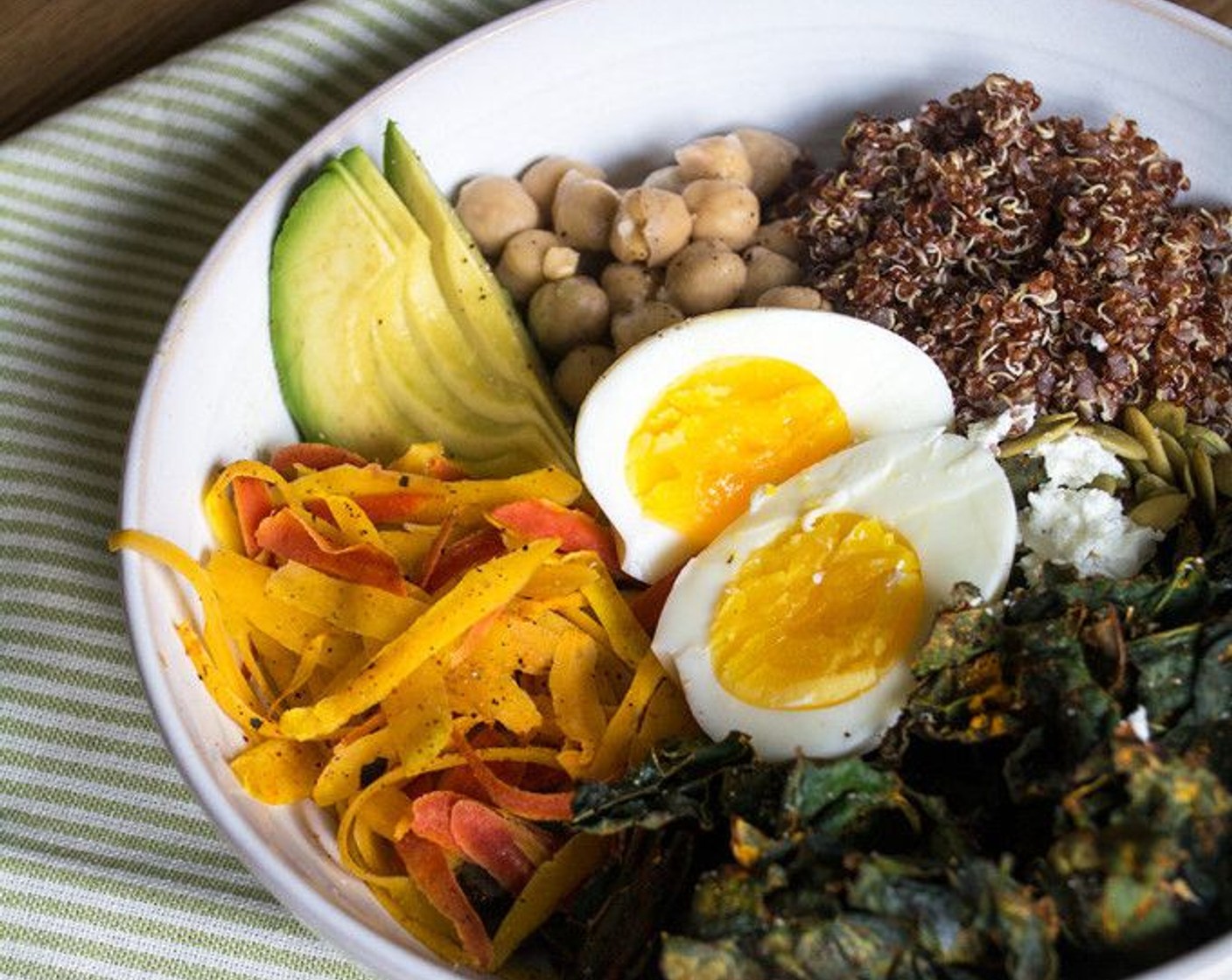 step 10 In two bowls, add cooked quinoa, baked kale chips, Canned Chickpeas (1/2 cup), shaved carrots, Avocado (1/2), Goat Cheese (2 Tbsp) and Pepitas (2 Tbsp) then top with soft boiled egg and sprinkle with salt and pepper if desired.