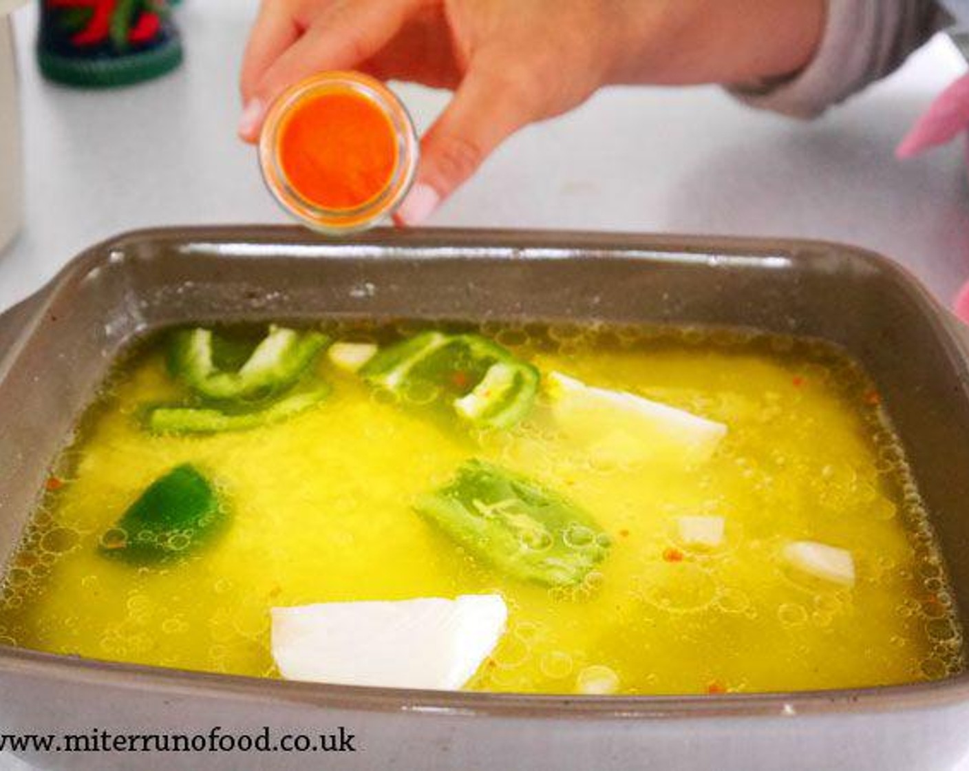 step 2 In a baking tray, add White Rice (1 cup), Green Bell Pepper (1/4), Onion (1/2), Salt (1 tsp), Vegetable Oil (3 Tbsp), Garlic (4 cloves), Water (2 cups), and Yellow Food Coloring (1 pinch).