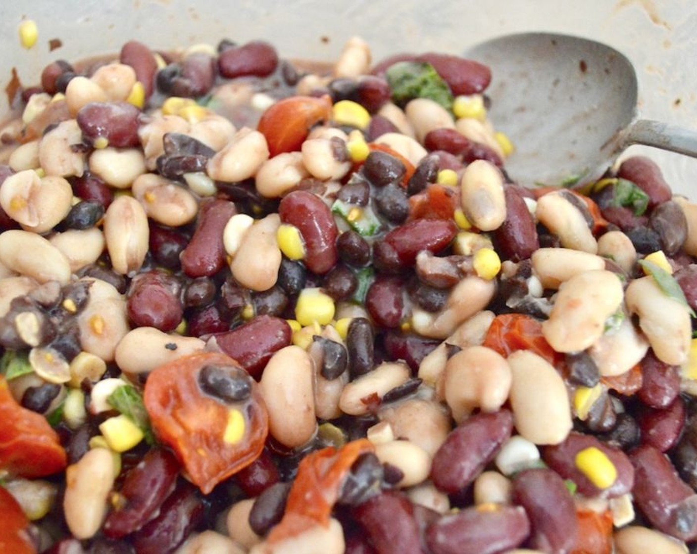 step 3 When they are done, combine them in a large bowl with White Beans (1 can), Red Kidney Beans (1 can), Black Beans (1 can), Fresh Basil Leaves (3), and juice from the Lemons (2). Toss the salad together thoroughly, then let chill for an hour at least in the refrigerator.