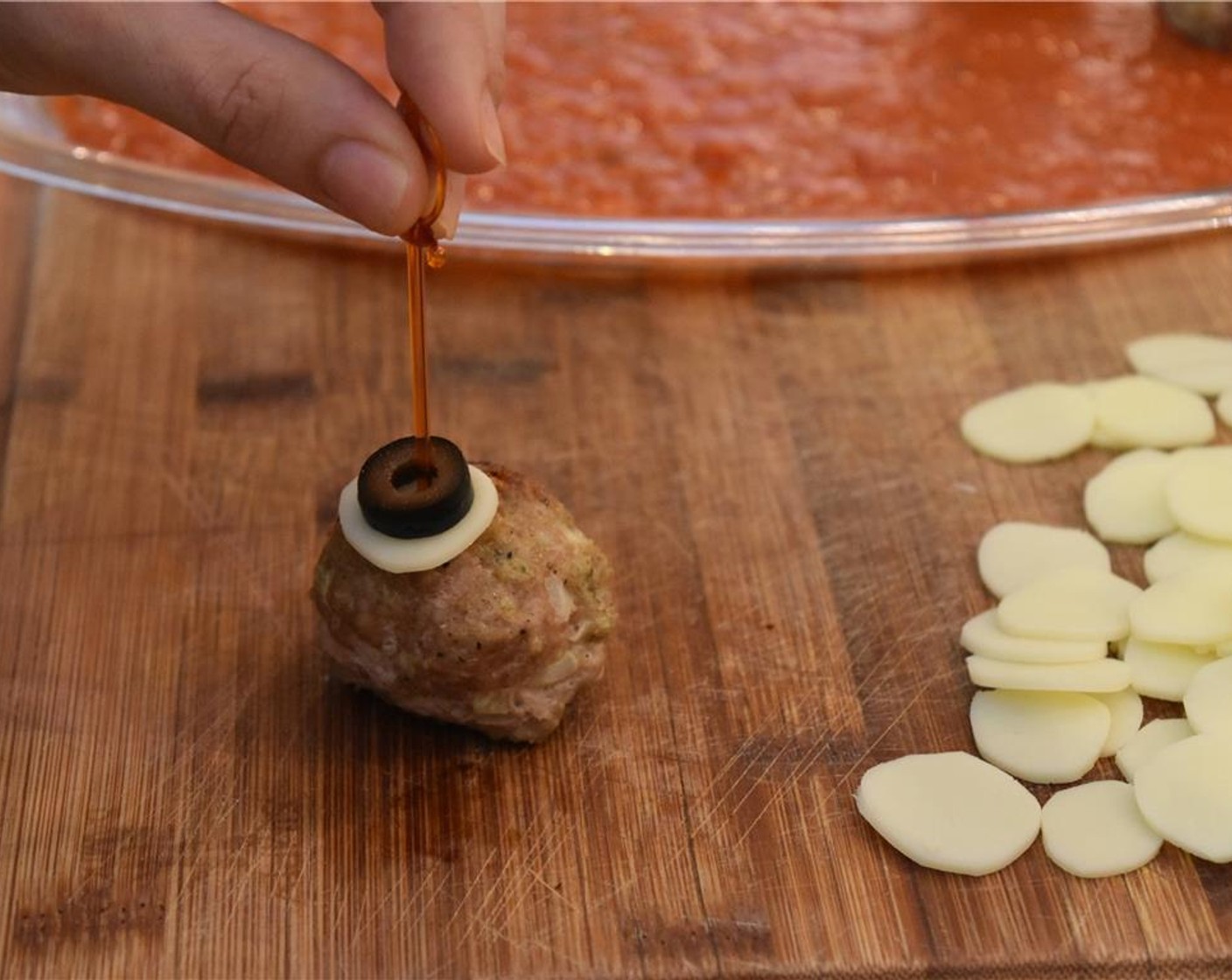 step 6 Stack a provolone circle and then a piece of Black Olives (1 1/4 cups) atop the meatball. Skewer a toothpick through to keep it intact.