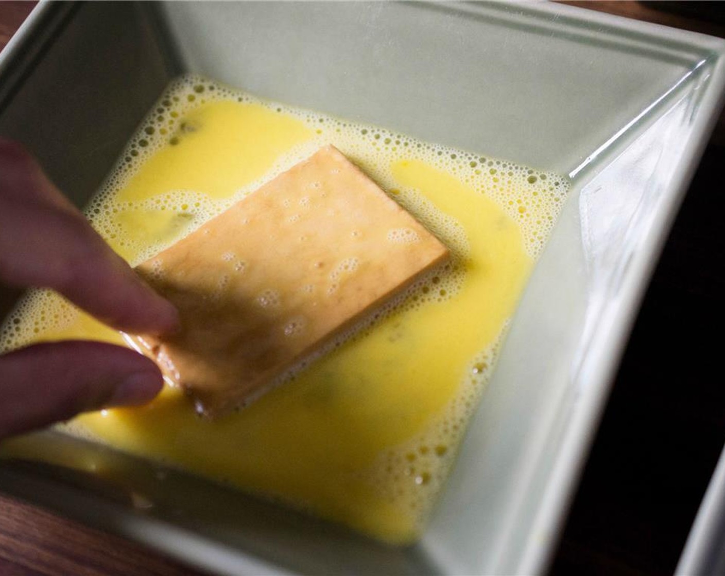 step 6 Working with one slice at a time, dip the tofu in the egg mixture, being sure to coat the entire piece.