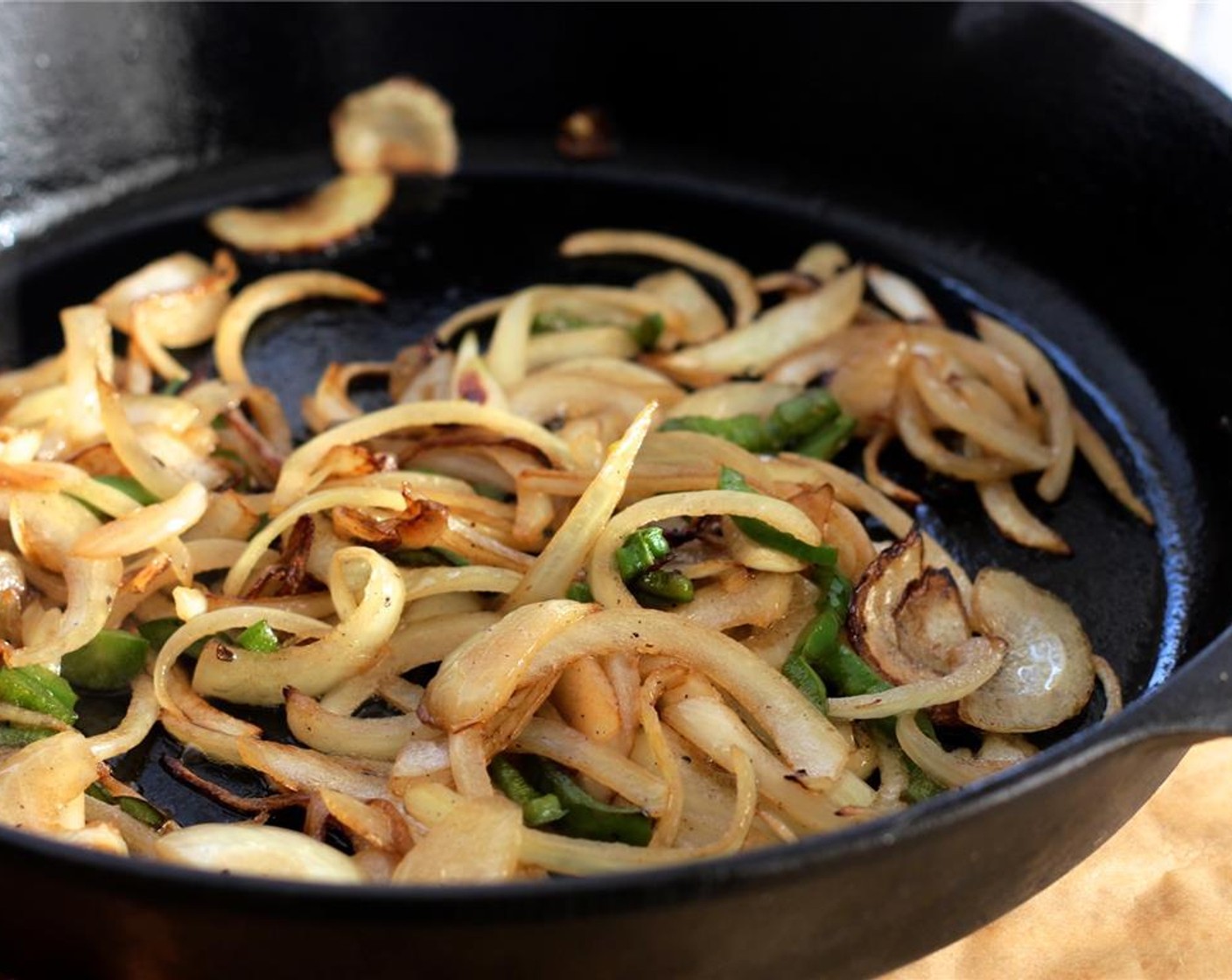 step 7 For the sauce, add Olive Oil (2 Tbsp) to the same skillet and cook the onions and jalapeno until golden.
