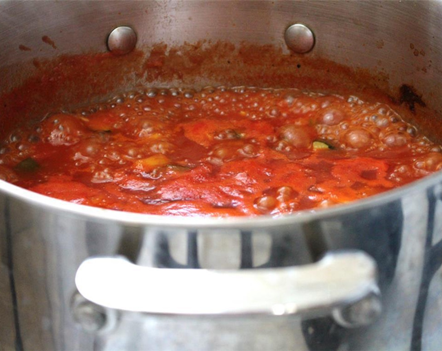 step 2 Add Chili Pepper (1/2) and cook for 2 minutes. Add Garlic (3 cloves) and cook for 1 minute more. Add Canned Crushed Tomatoes (2 cups), Water (3 cups), and Maple Syrup (1 Tbsp). Bring to a boil, then reduce to a simmer and cook for about 10 minutes.