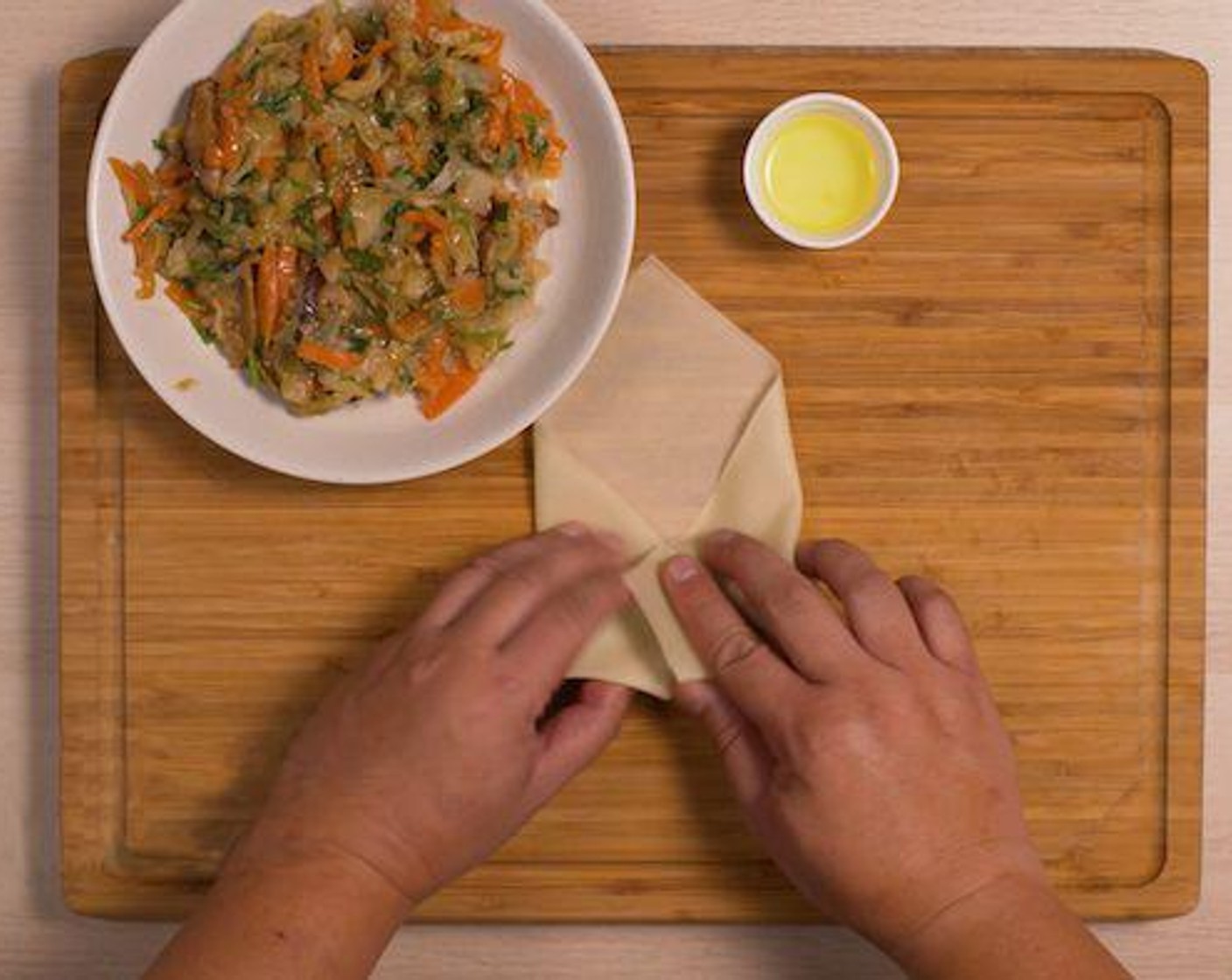 step 3 Place a sheet of Spring Roll Wrappers (8 sheets) on a cutting board. Place some filling and roll into a spring roll. Apply a brush of the white part of the Egg (1) to seal the spring roll. Repeat until filling is used up.