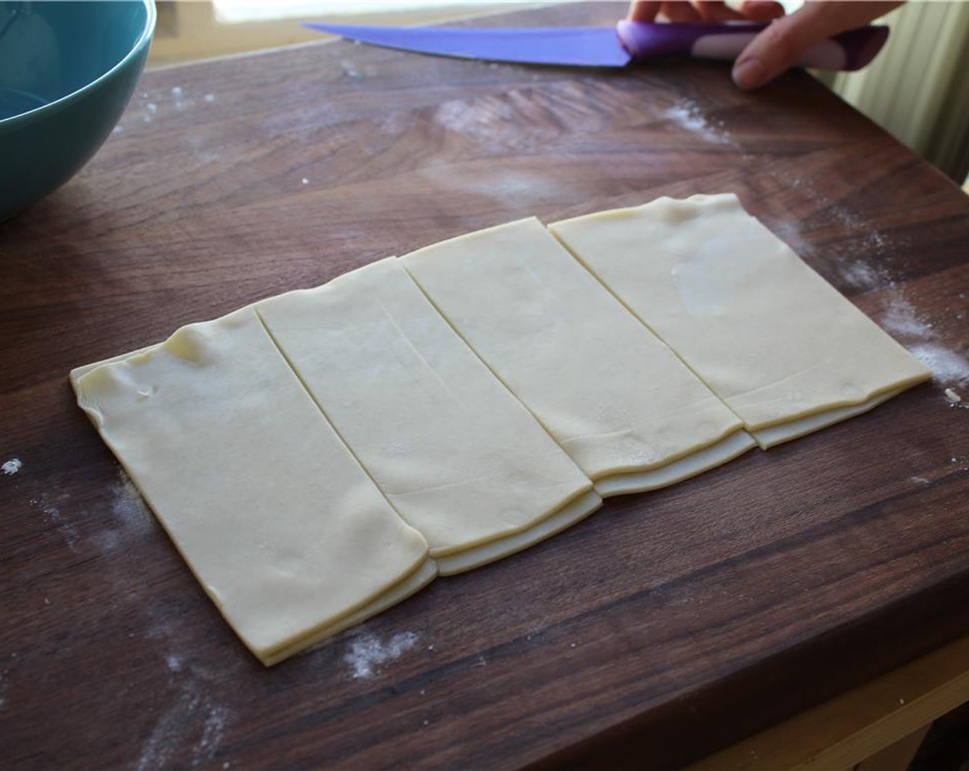 step 3 Cut the sheet of dough down the middle and stack the two halves. Then, slice the dough into four equal rectangles. They should be approximately 3x4 inches.