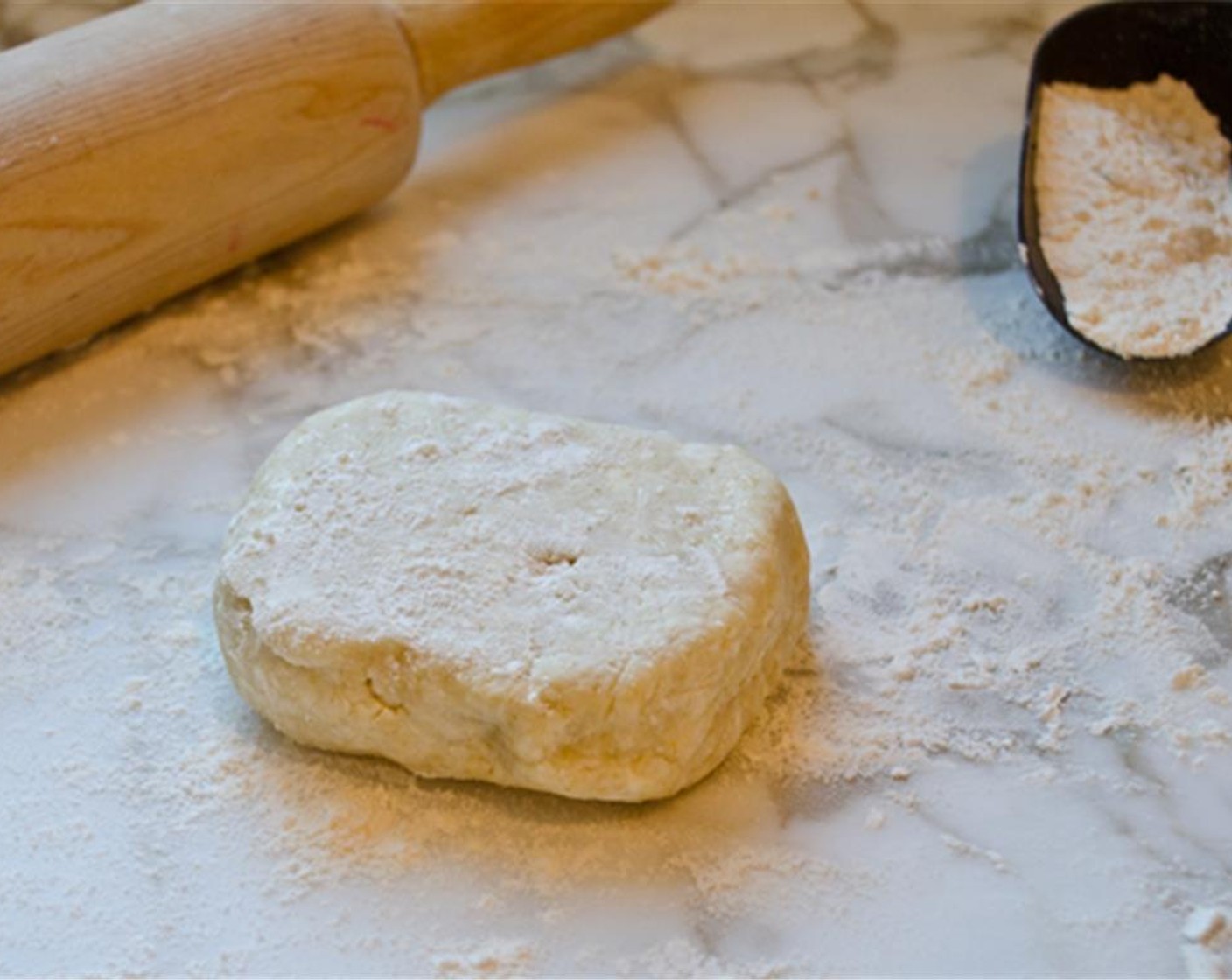 step 7 Remove one disc of dough from the refrigerator, unwrap it and place it on a lightly floured work surface. Dust the top of the dough lightly with flour, then use a rolling pin to roll it into a 10-11 inch circle, or just under an 1/8 inch thick.
