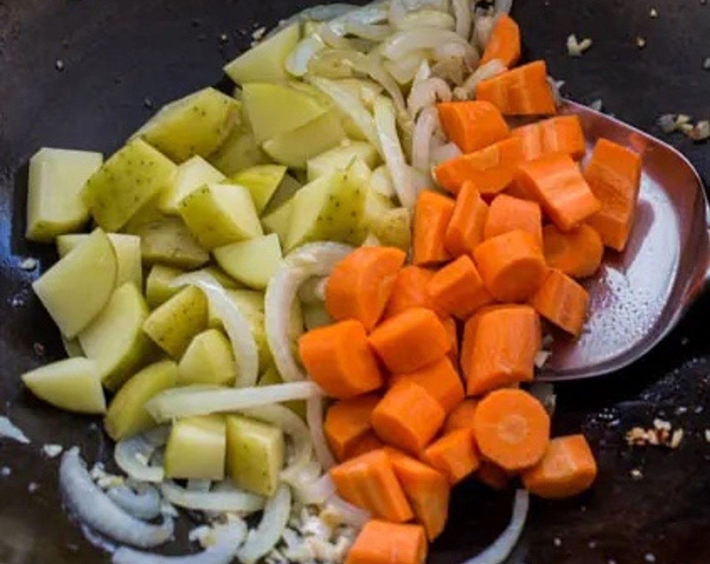 step 2 Add Yukon Gold Potatoes (2) and Carrots (2) to the wok. Stir occasionally for 2 minutes.