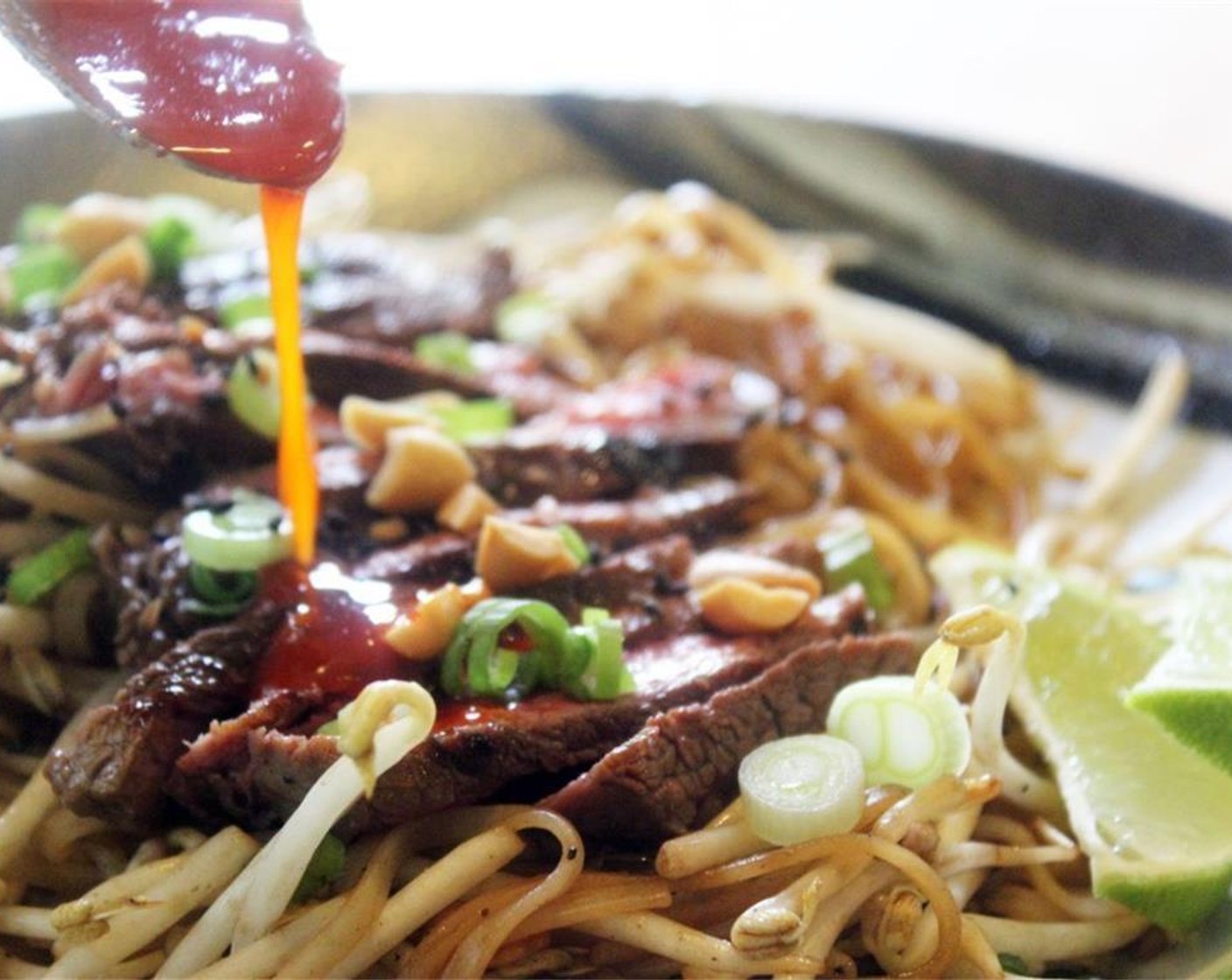 step 13 To serve, top the noodles in bowls with some of the steak, Sesame Seeds (1 Tbsp)m and lime wedges. Drizzle with hot sauce.