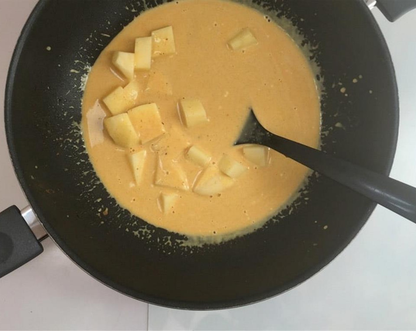 step 4 Stir and bring the curry to a gentle boil. Add the potatoes to the curry.