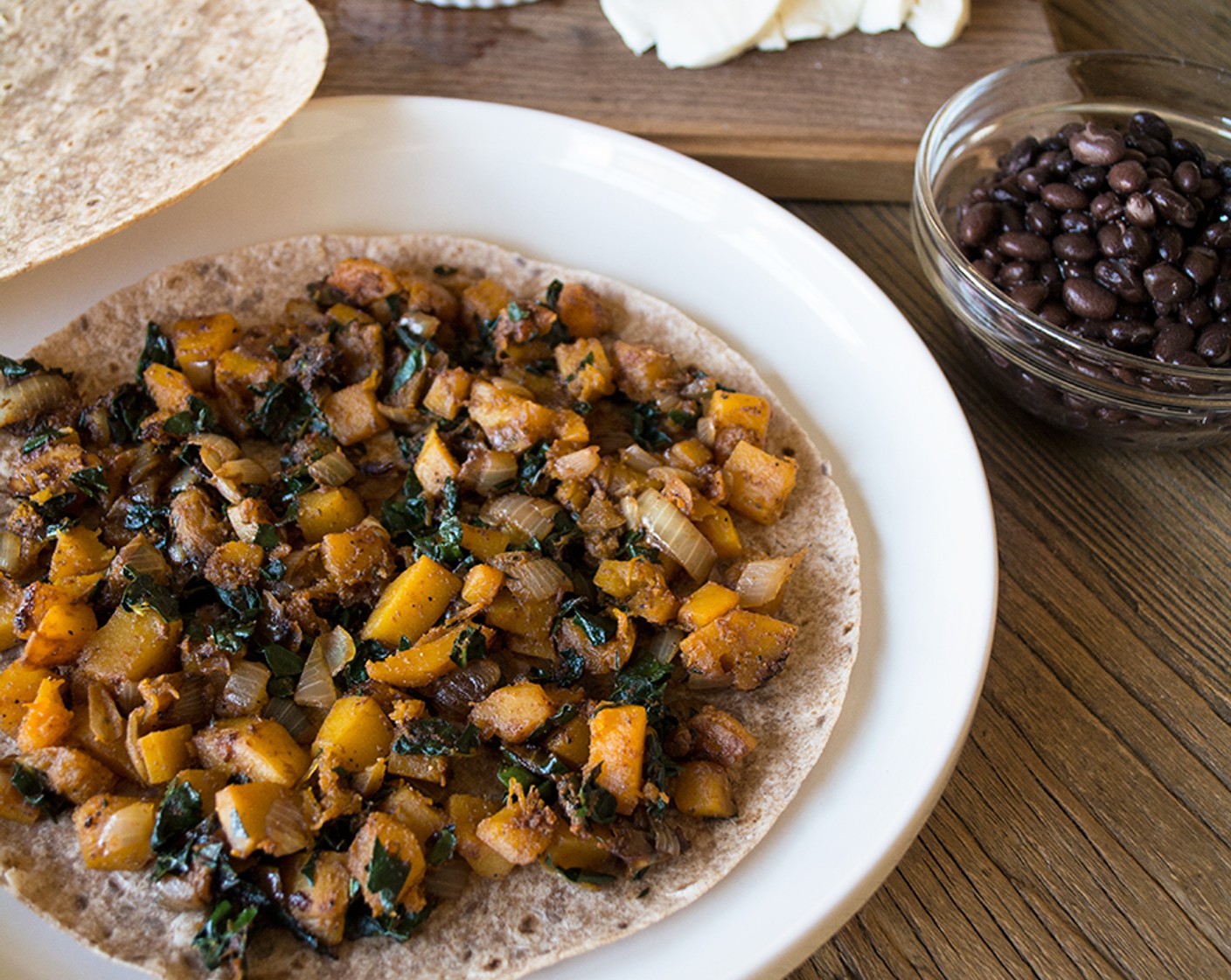 step 3 Spread out half of the cooked veggies, then top with one-quarter GOYA® Black Beans (1/2 cup) and approximately Shredded 2% Mozzarella Cheese (1/2 cup) on one Whole Grain and Flax Tortillas (4).