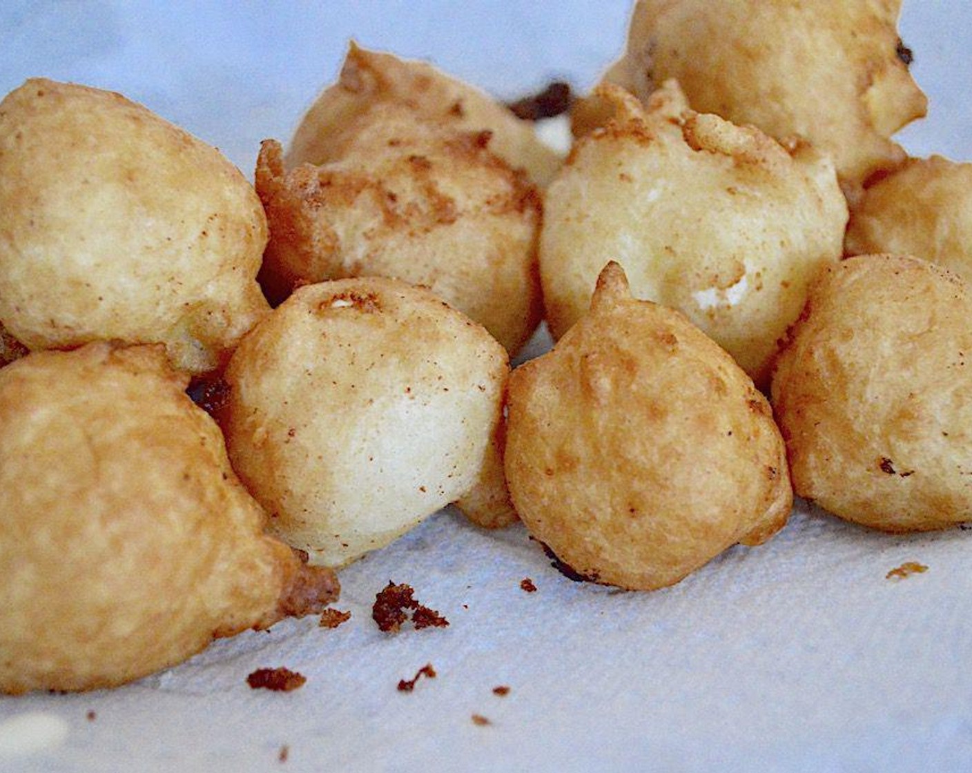 step 5 Get out the goat cheese balls and batter. In batches of two, coat the goat cheese balls in the seasoned flour first, followed by the batter. Drop them in the oil and stir them around so that they don't stick.