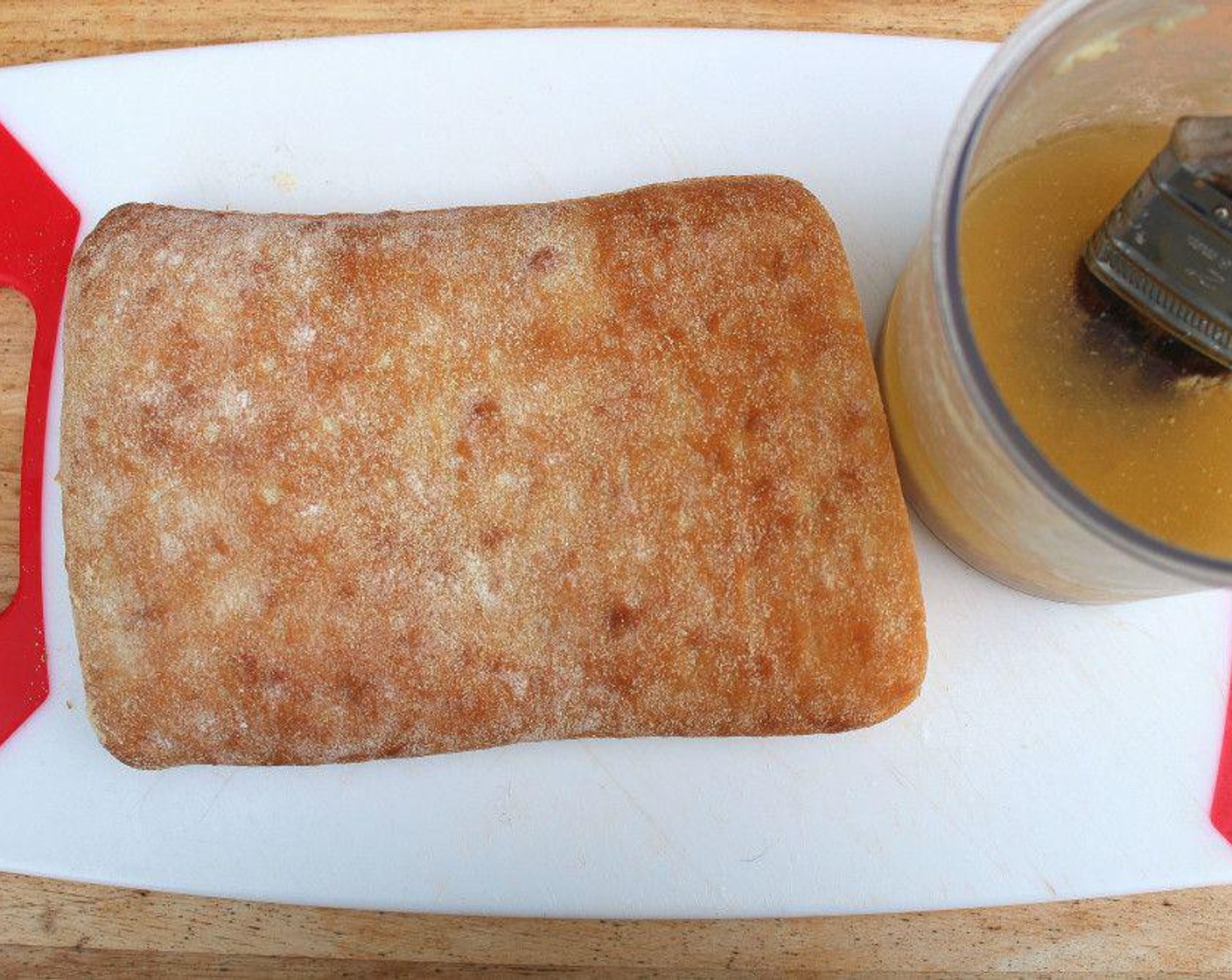 step 1 Cut the Focaccia Bread (1 loaf) in half, brush generously on all four side with Garlic Paste (to taste).