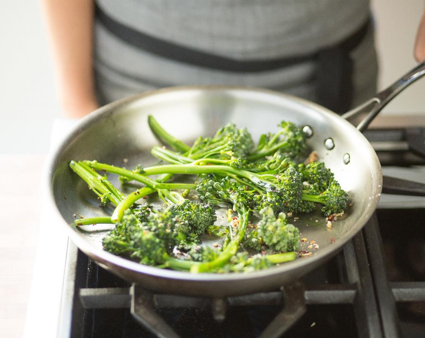 step 13 Heat Olive Oil (1 tsp) in a large sauté pan over medium-heat. Place the broccolini and Salt (1/4 tsp) and Ground Black Pepper (1/4 tsp); cook for 4 to 5 minutes.