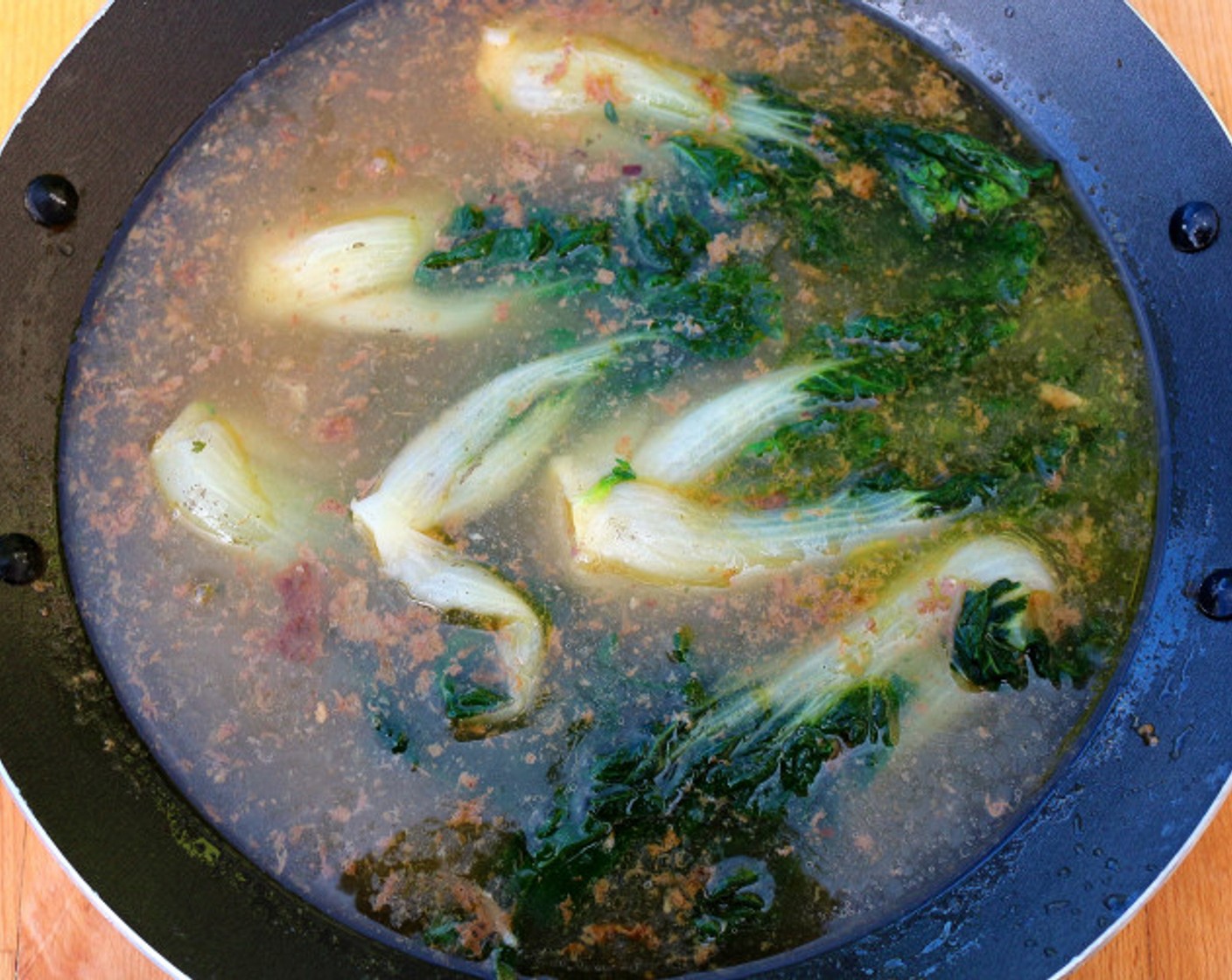 step 10 With a slotted spoon, remove all bones and solids, and add blanched, shocked and drained Baby Bok Choy (6 cups), simmer for 1 minute, remove from heat, check and adjust seasoning.