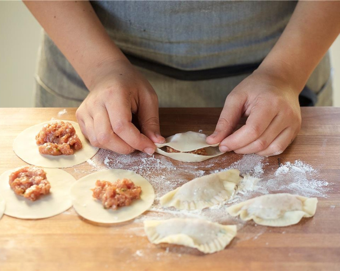 step 10 Scoop two teaspoons of pork filling on each wrapper slightly off center toward the upper half of the wrapper. Brush the edges with water, and fold the wrappers diagonally to enclose their filling, using a fork to crimp the edges.