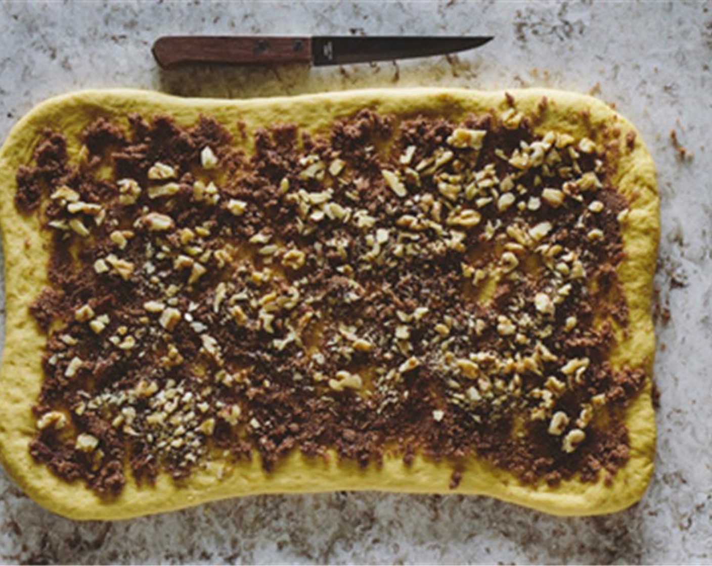 step 9 Transfer the dough onto your kitchen counter and roll it out to a 12x9-inch rectangle. Sprinkle it with the walnut mixture.