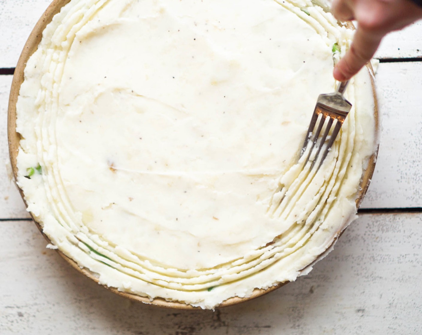 step 8 Transfer the filling to a 9x9 baking dish or 12-inch round dish. It can also be cooked and baked in a cast-iron skillet. Spoon over the mashed potatoes and spread evenly, smoothing the top with the back of a spatula or spoon. If desired, use a fork to create a swirl pattern in the potatoes. Bake for 30 minutes.