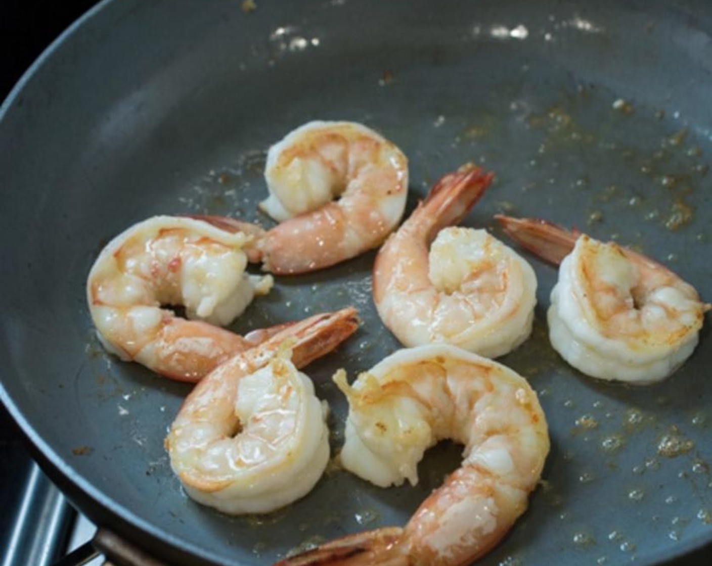 step 5 Place a separate shallow frying pan on your stove-top over medium-high heat. Pour 2 tablespoons of the garlic oil in this frying pan, then pan-fry the Large Shrimp (12) in batches. Set the shrimp aside when fully cooked.